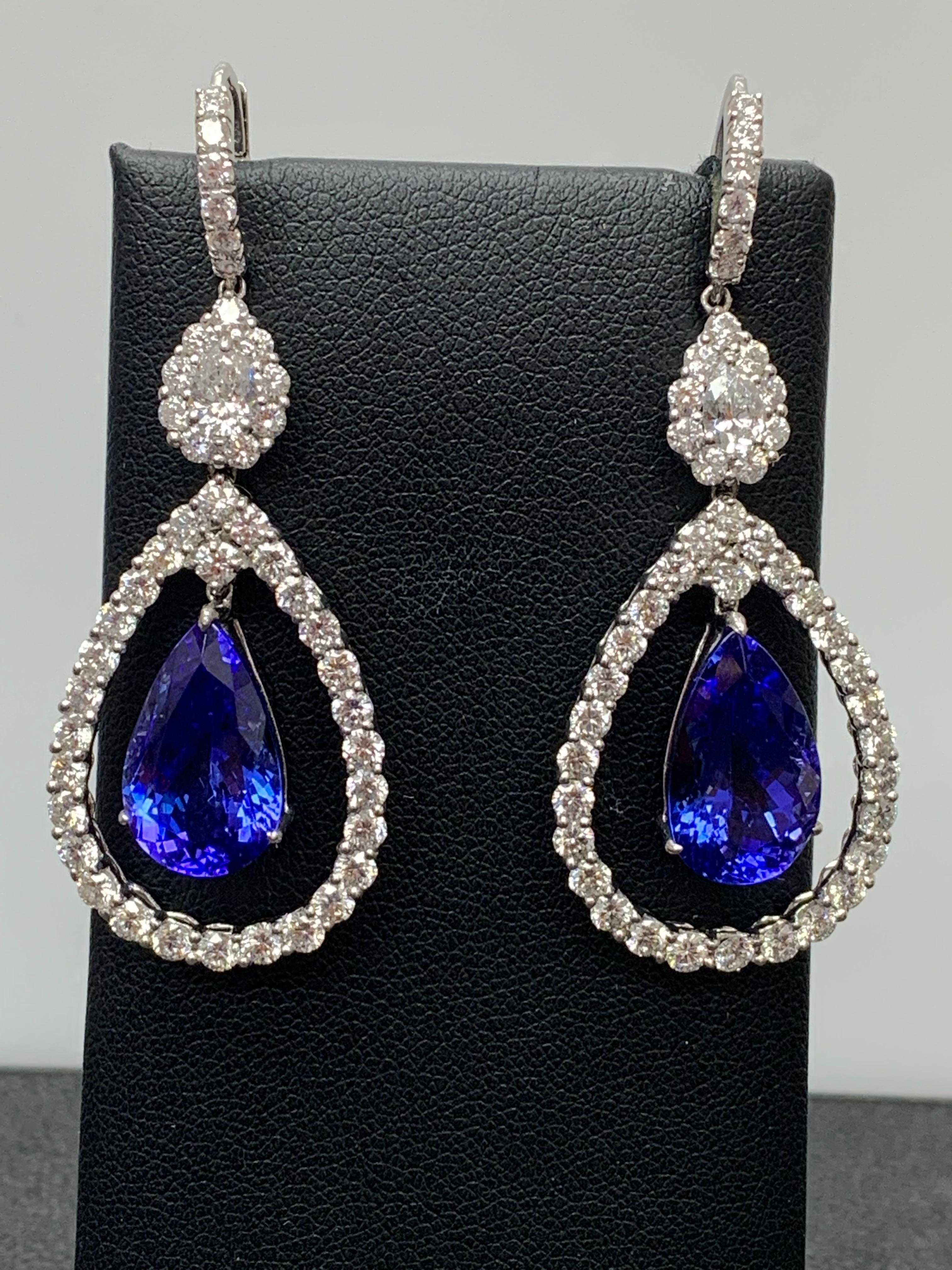 Dangle earrings featuring 2 Pear shape Tanzanites weighing 11.35 carats total, Set in an open work design. Surrounded by a row of round brilliant diamonds. 88 Accent Diamonds weigh 4.10 carats and 2 pear shape diamonds weigh 0.61 carats in total.