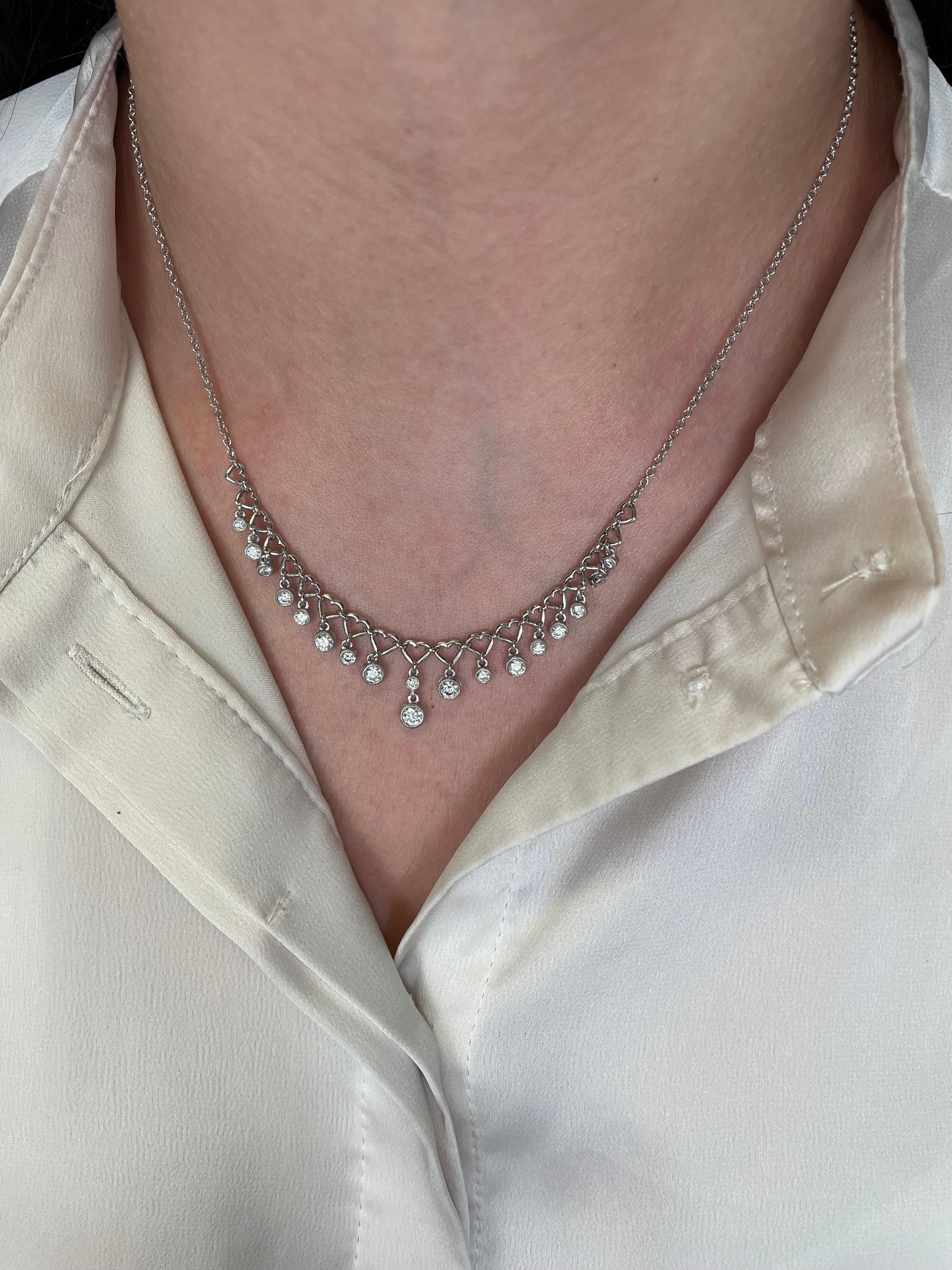 Lovely dangling diamond necklace with heart design, bezel set.
18 round brilliant diamonds, 1.13 carats. Approximately G/H color and SI clarity. 18-karat white gold.
Accommodated with an up to date appraisal by a GIA G.G. upon request. Please