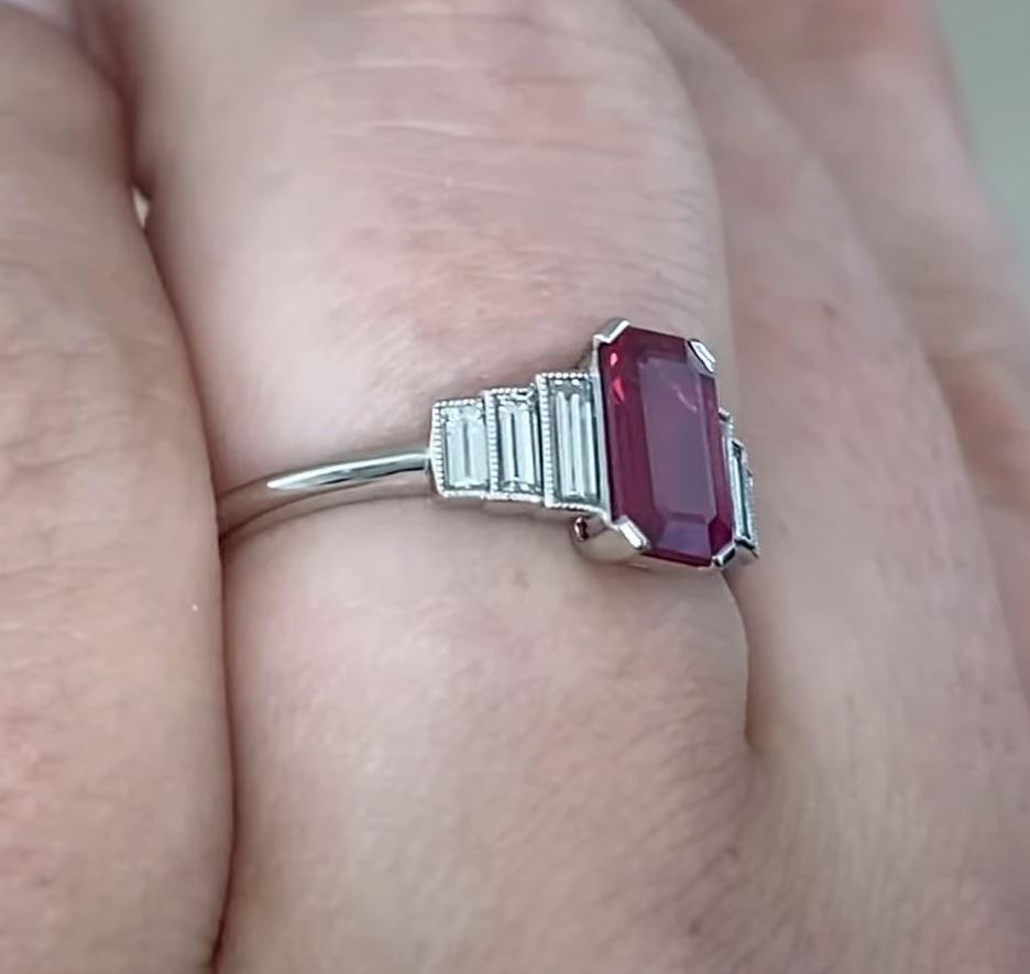 This exquisite ring showcases an elongated emerald-cut natural red ruby at its center, weighing approx. 1.10-carats. The deep, vibrant hue of the ruby is complemented by its striking emerald-cut shape, which enhances its natural brilliance and