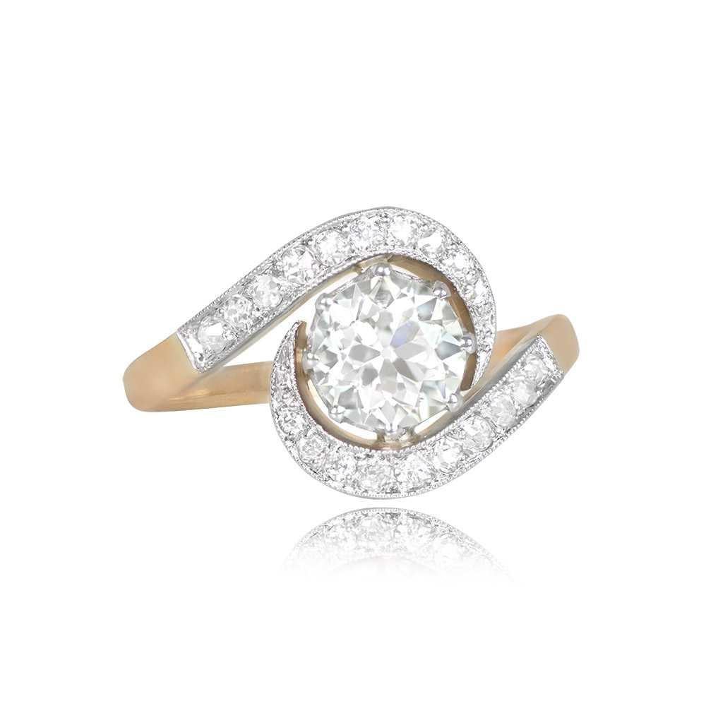 This captivating swirl ring features a central old European cut diamond, approximately 1.13 carats in weight, with I color and VS2 clarity, elegantly set within prongs. The unique design showcases a ribbon motif, meticulously pave-set with