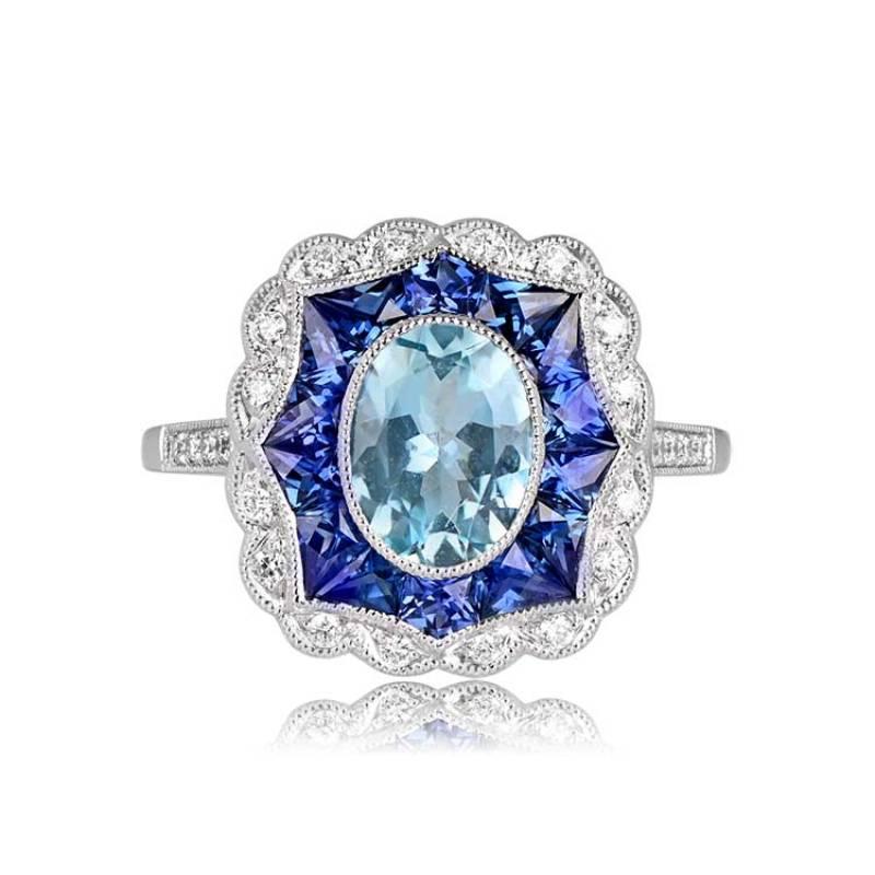 This charming ring features a 1.13-carat natural oval-cut aquamarine at its center, complemented by a halo of French-cut sapphires totaling 0.90 carats. The ring is further adorned with brilliant-cut diamonds in both a halo and shoulder accents,