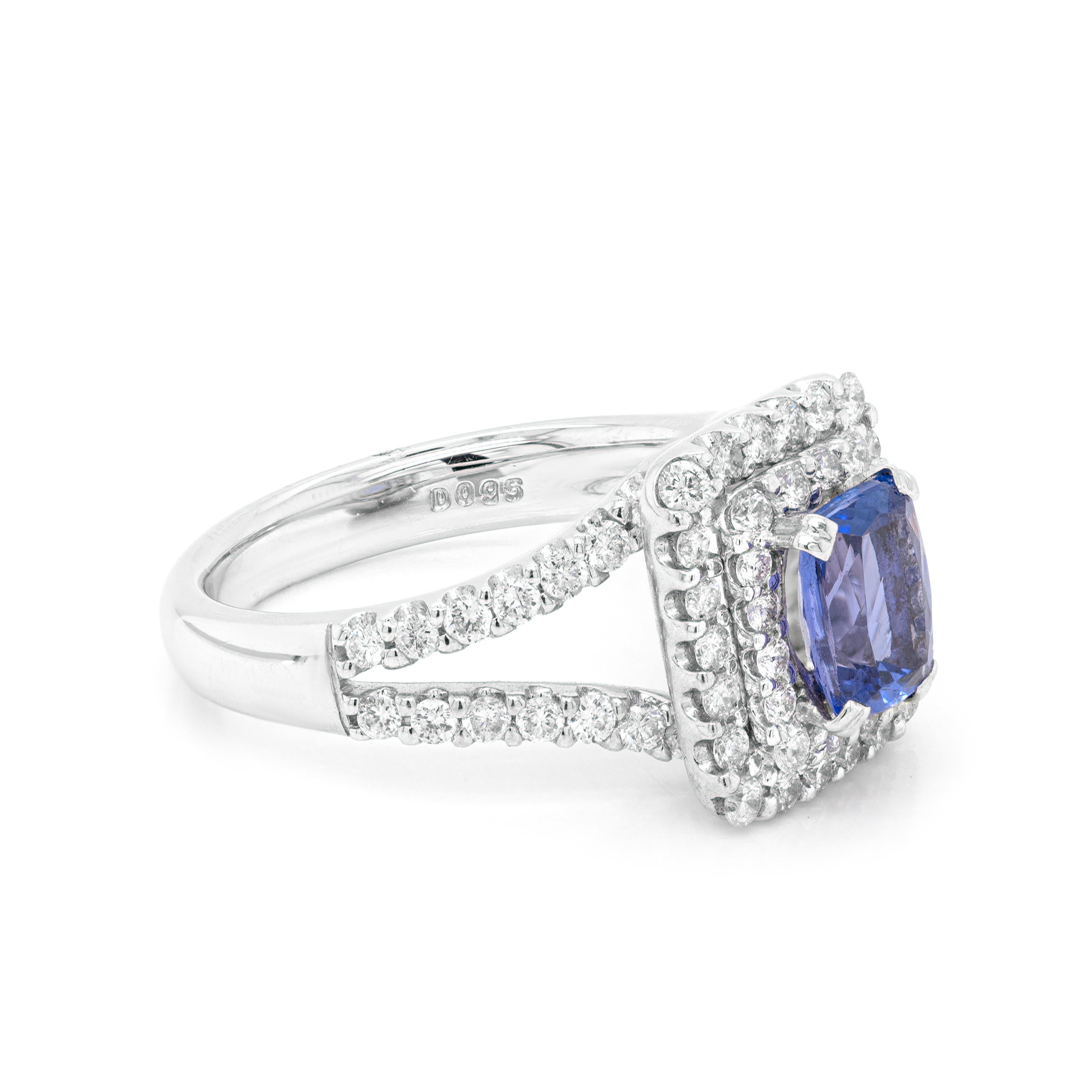 This exquisite 18 carat white gold engagement ring features a wonderful 1.13ct cushion shaped tanzanite mounted in a four claw, open back setting. The vivid stone is surrounded by a rectangular double halo of 38 round brilliant cut diamonds,