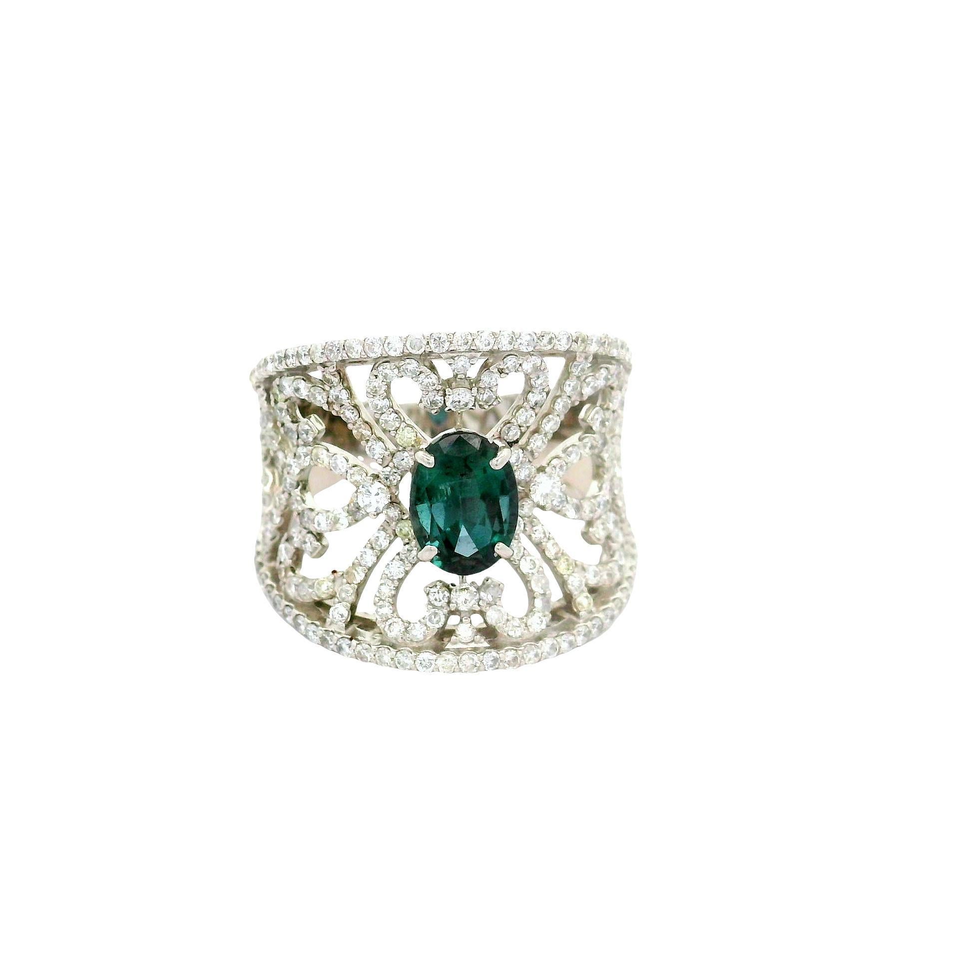 Un anello di grande effetto con un'alessandrite ovale da 1,14 carati di colore blu verdastro che vira al viola. La tonalità verde intenso dell'alessandrite è elegantemente incorniciata da un reticolo di diamanti bianchi rotondi, per un totale di