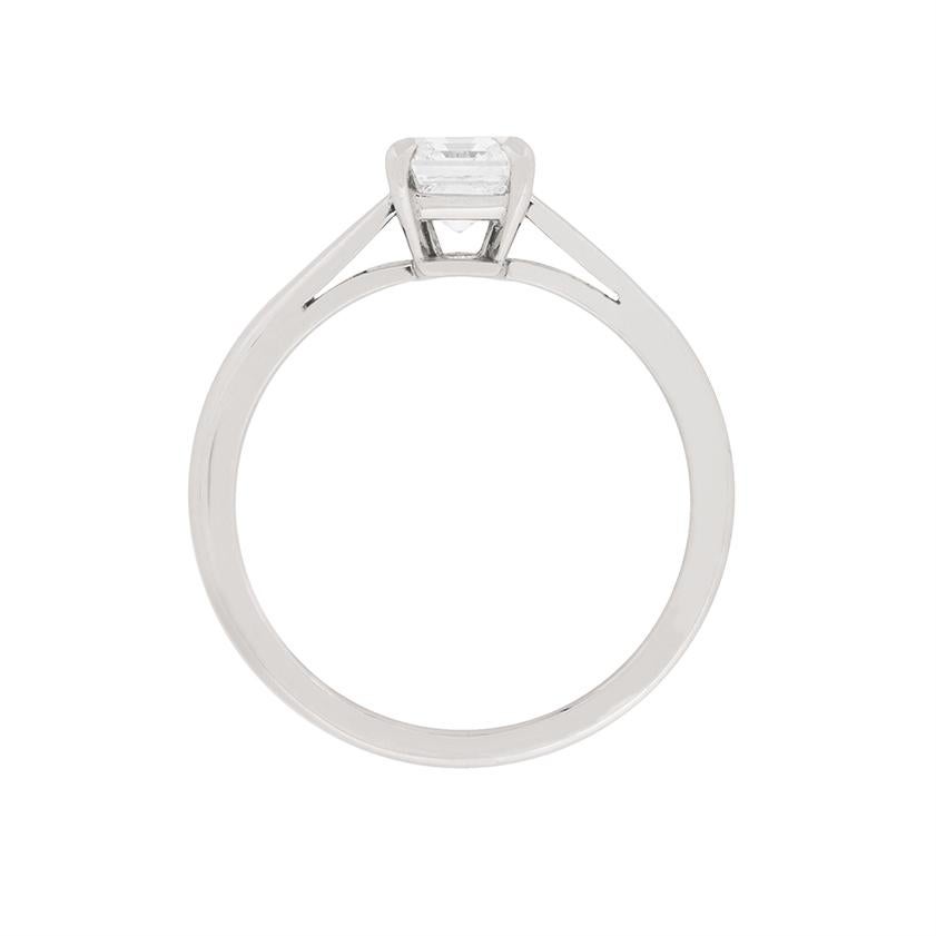 This elegant and stunning diamond solitaire ring hails from the Cartier collection. The piece has original makers marks and authenticated paperwork from Cartier, serial number: HLS02487. The piece features a single stone, emerald cut diamond,