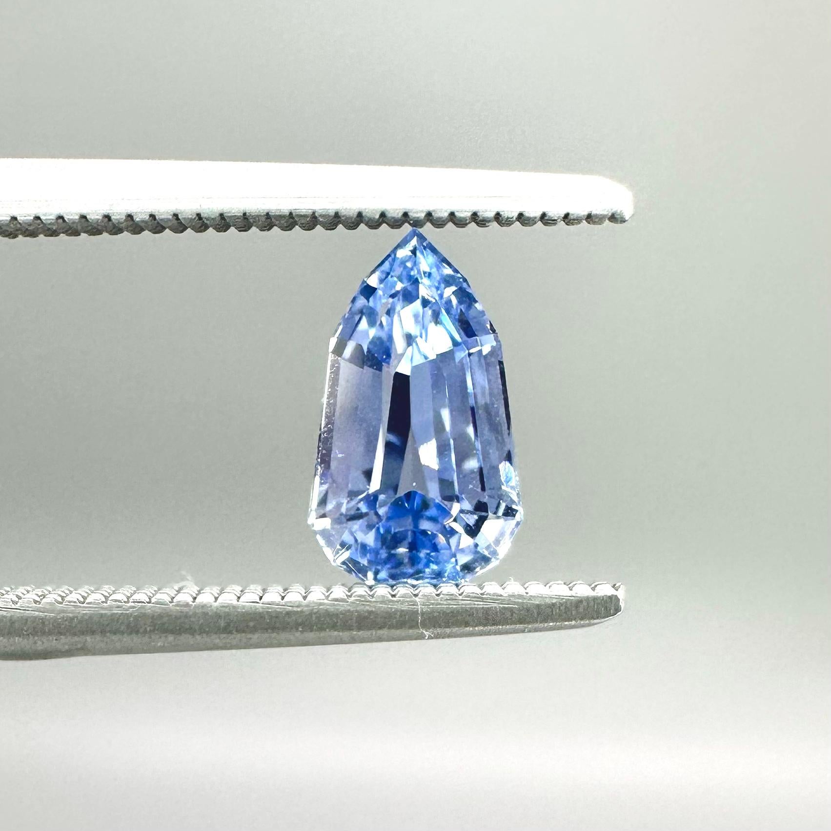The pale ice blue and sharp, clean cut facets of this brilliant little sapphire invoke an arctic blast of winter air that rattles the icicles hanging from the eves. 

This beautiful and unusual 1.14 carat sapphire sports a modified shield cut, and