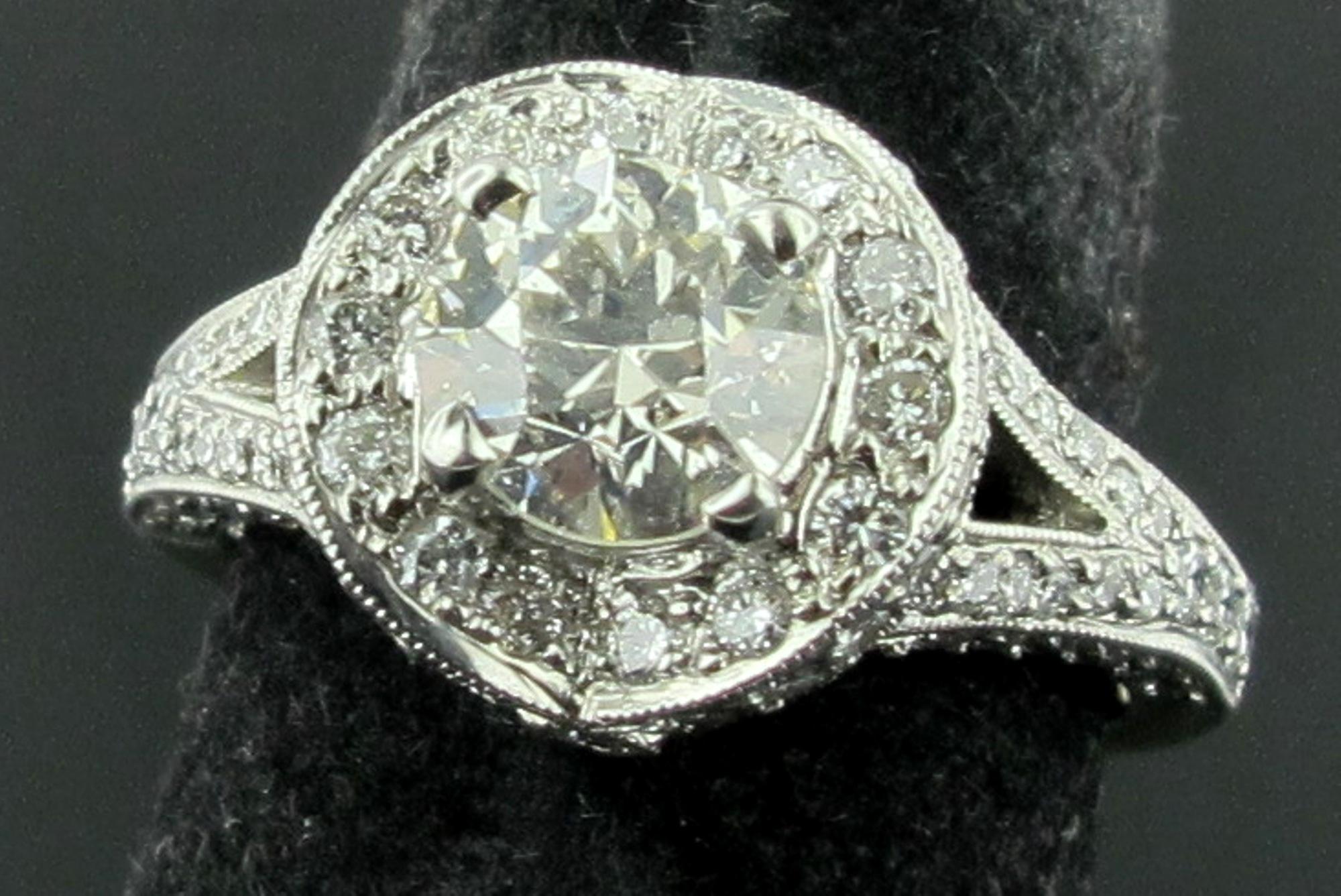 In 18 Karat Weißgold gefasst ist ein 1,14 Karat schwerer Diamant im Old European Cut mit weiteren 0,89 Karat Diamanten in der modernen Fassung.  Das Gesamtgewicht der Diamanten beträgt 2,03 Karat.  Ringgröße ist 6. Der Diamant in der Mitte hat die