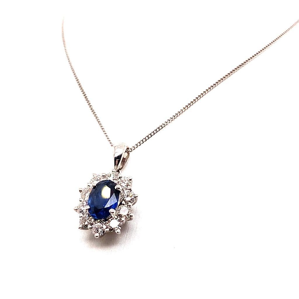 This stylish pendant is a true eye-catcher featuring an Oval Blue Sapphire weighing approximately 1.14 Carats. The delicate hues of this dark blue stone is surrounded by Diamonds weighing approximately 0.51 Carats which provide a clear contrast
