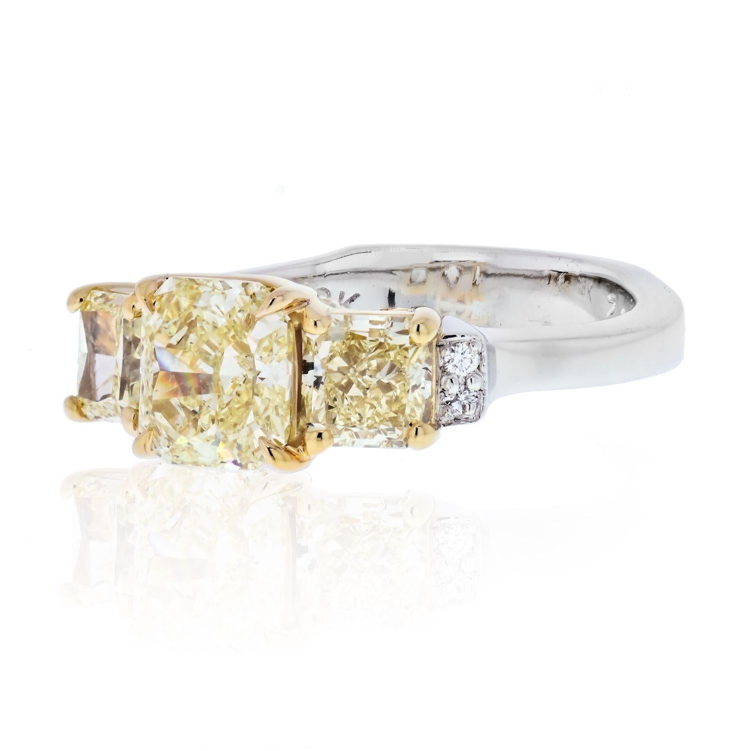 Three stone fancy yellow radiant cut diamond ring crafted in Platinum with 18K yellow gold baskets. Fine ring with GIA certified diamonds.
Center diamond is a 1.14 carat VS2 clarity diamond of natural fancy yellow color. 
Flanked by two matching