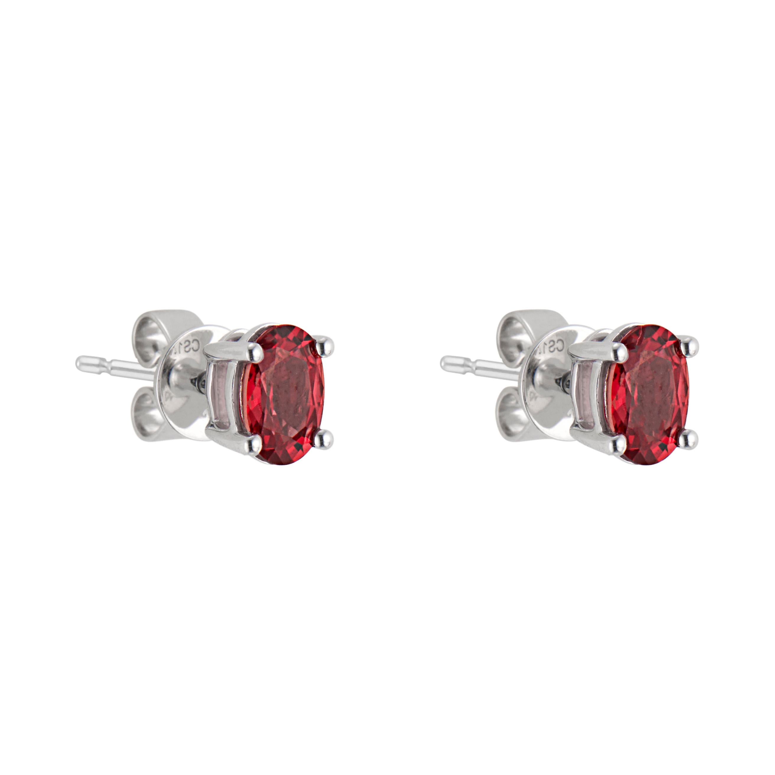 2 oval red with a bit of orange sapphires, set in 14k white gold 4 prong simple basket stud settings. 

2 oval red orange sapphires, approx. 1.14cts
14k white gold 
Stamped: 14k
1.5 grams
Top to bottom: 6mm or .25 Inches
Width: 4.5mm or .18