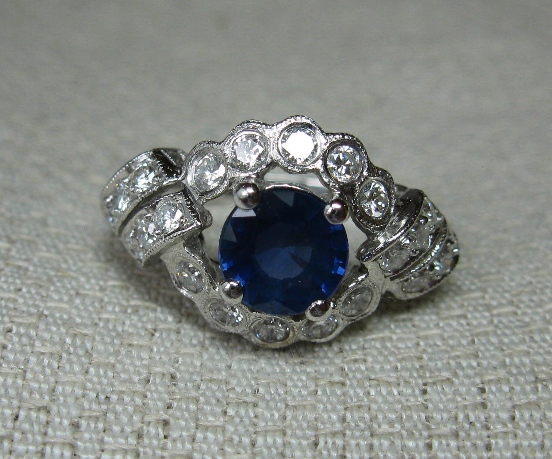 This is a stunning 1.14 Carat Sapphire Diamond Platinum Wedding Engagement Ring.  The central sapphire is a stunning fine blue color.  The sapphire is accented with 22 Round Brilliant Cut Diamonds of F/G color - very white.  The diamonds total .54