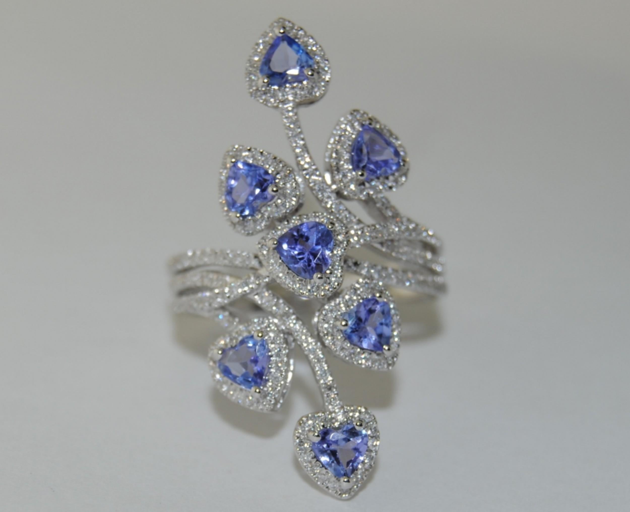 This unique ring has 7 Pear Shape Tanzanites totalling 1.14 carats.  Set in 14 Karat white gold and surrounded by .49 carats of  brilliant white Round Diamonds .

Ring size  6.5