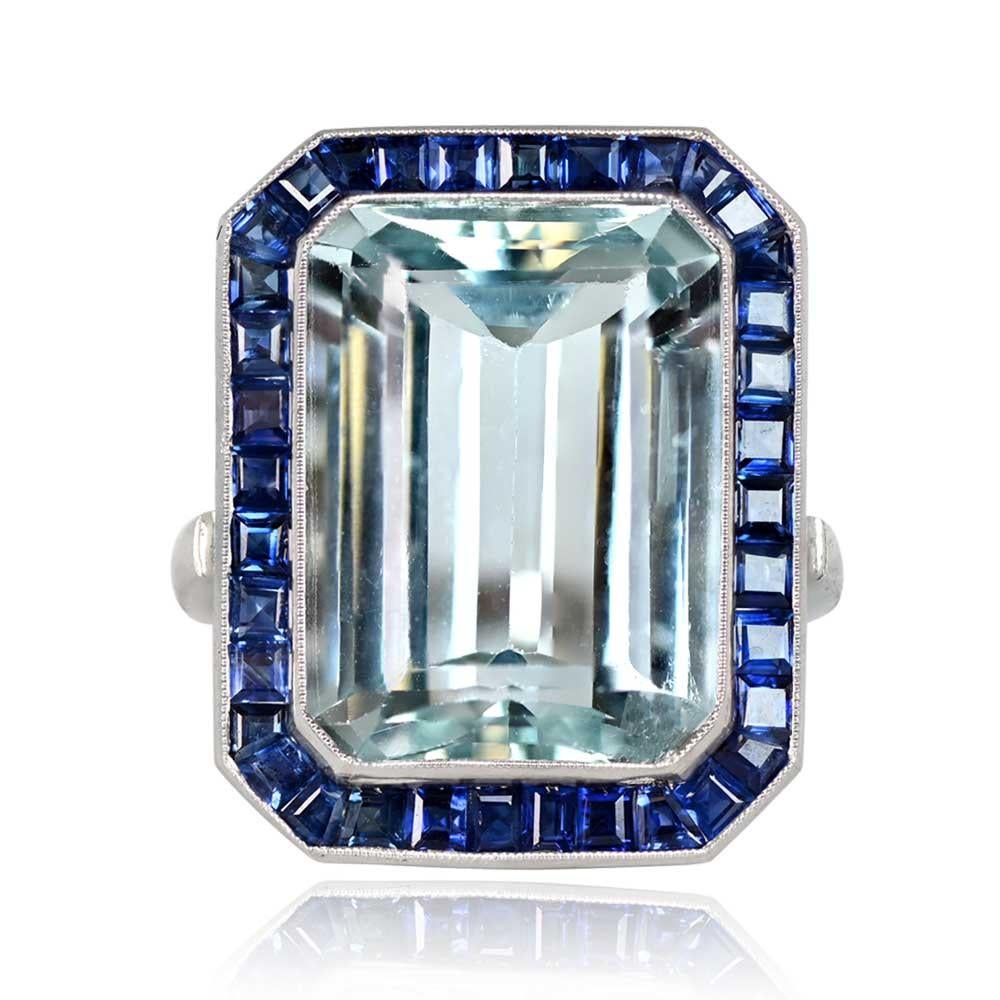 Ein bezaubernder Edelsteinring mit einem Aquamarin im Smaragdschliff von 11,41 Karat, umgeben von einem Halo aus natürlichen Saphiren im Kaliberschliff mit einem Gewicht von etwa 1,44 Karat. Die Schultern des Rings sind mit Diamanten im