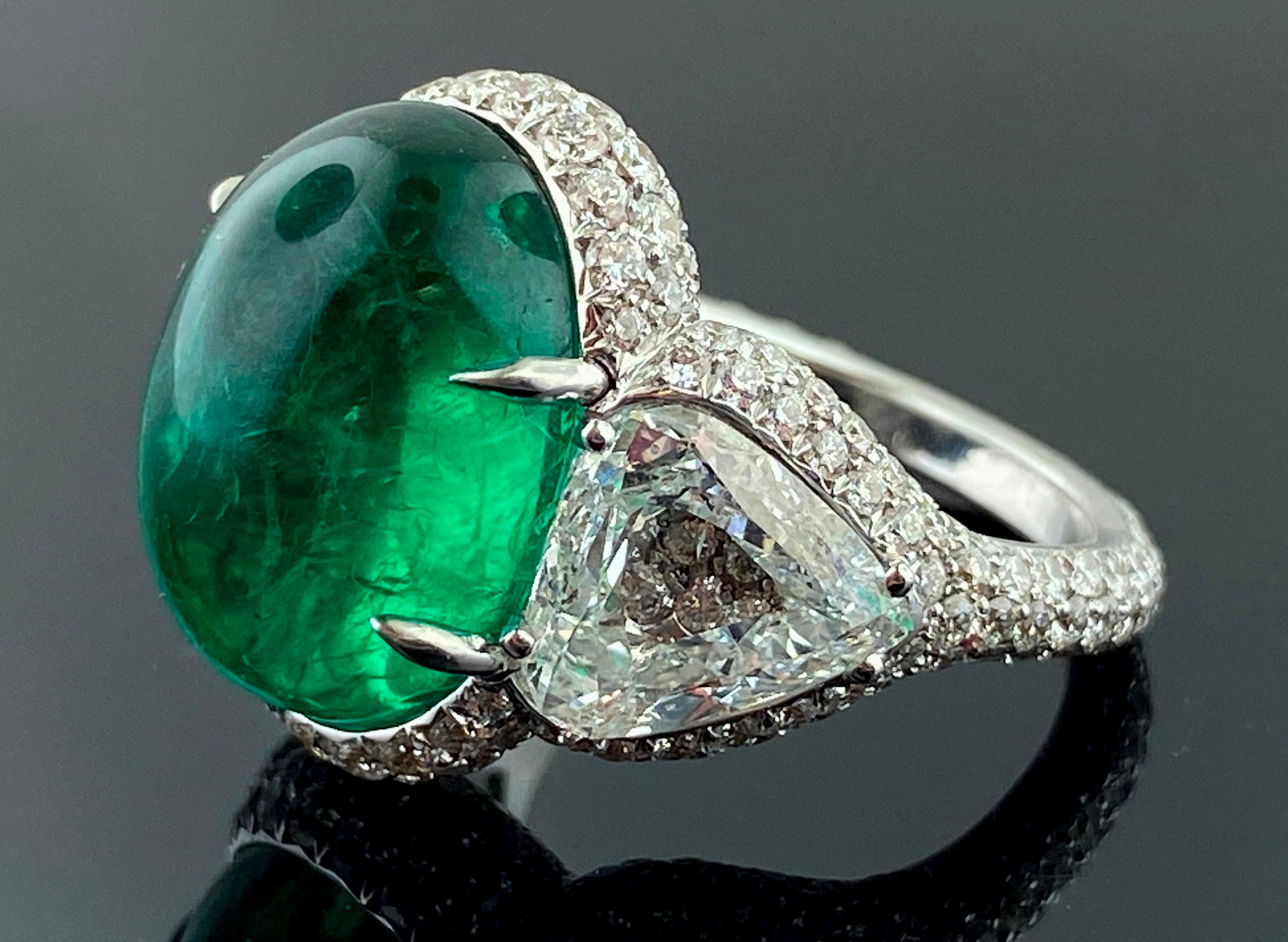 Set in 18 karat white gold is an 11.43 carat Oval Cabochon Emerald with 2 Trillion cut diamonds, weighing 4.02 carats total, plus 249 round brilliant cut diamonds with a total weight of 2.68 carats.  Total diamond weight is 6.70 carats.  Ring size