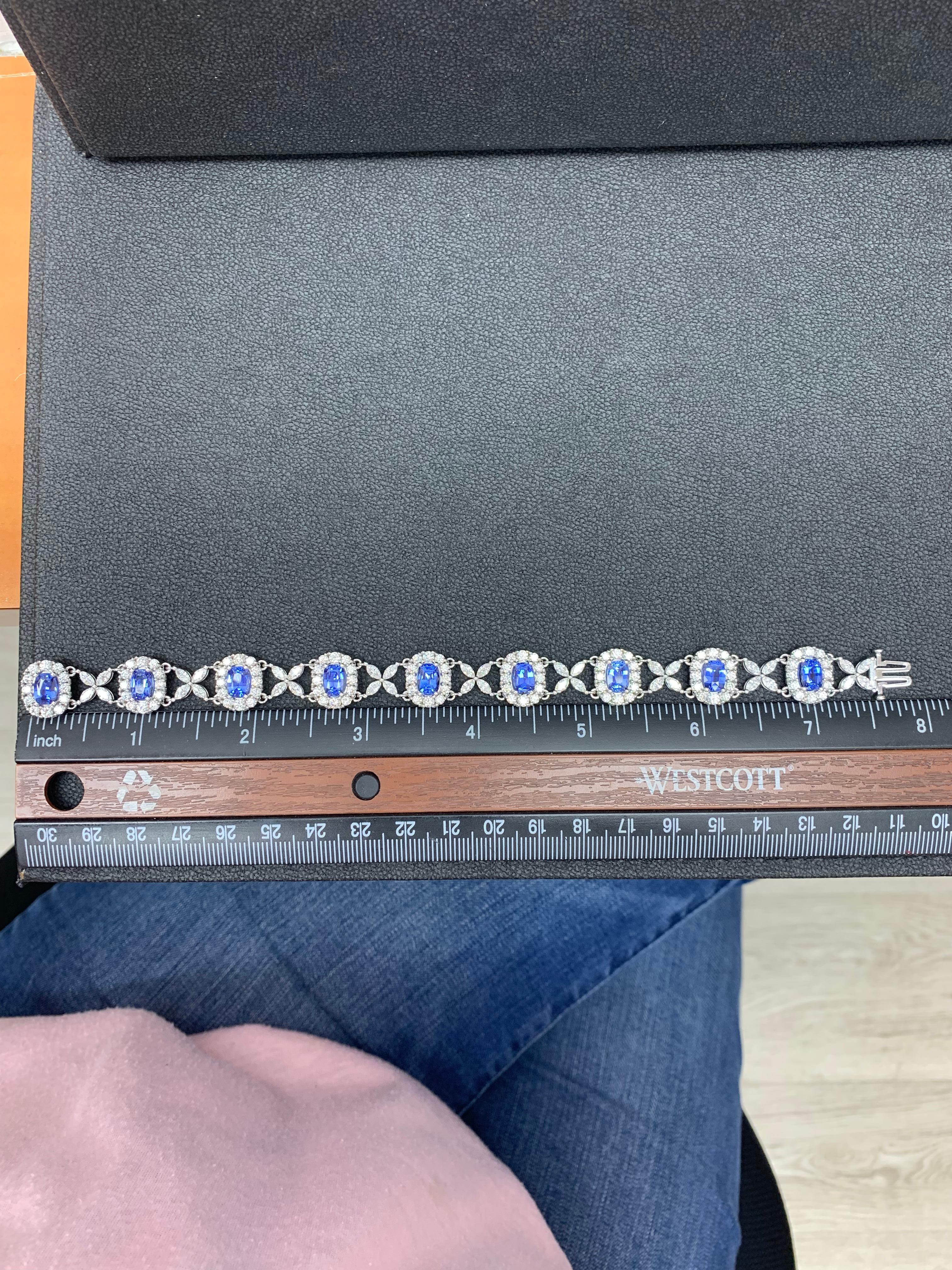 Gorgeous tennis bracelet set with 9 Blue Sapphires surrounded by brilliant cut round diamonds. These Blue Sapphires are linked with flower shape Marquise diamonds. Total weight of the Blue Sapphires is 11.47 carats; Total weight of the round