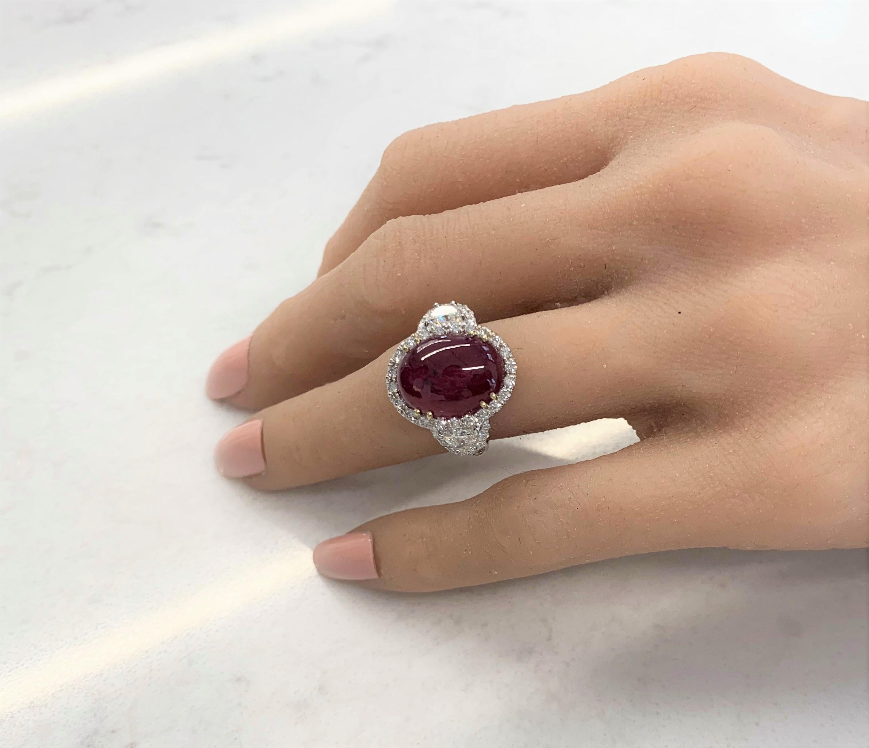 Perfect for those who appreciate the spectacular red color that ruby displays! This stunning brightly polished 18k white gold cocktail ring features a 11.48 carat oval cabochon Burmese ruby that displays an intense red hue, securely prong set in