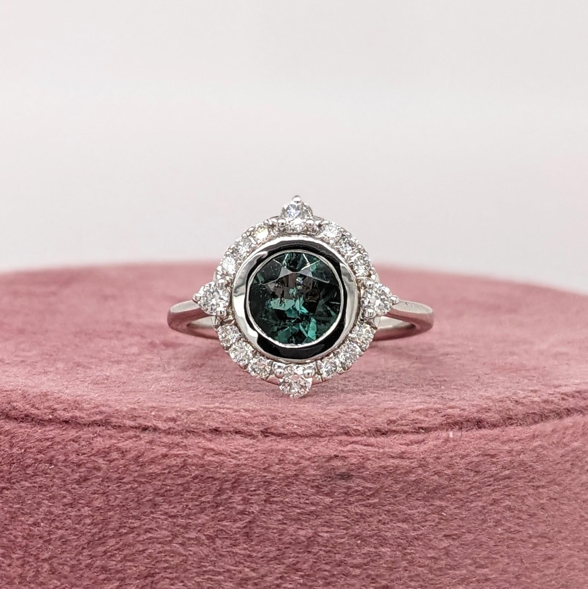 A unique statement ring design featuring a stunning round cut green-blue Indicolite Tourmaline wrapped in 14k white gold with natural diamond accents.

Specifications:

Item Type: Ring
Center Stone: Tourmaline
Treatment: Heated
Weight: 1.14ct
Head