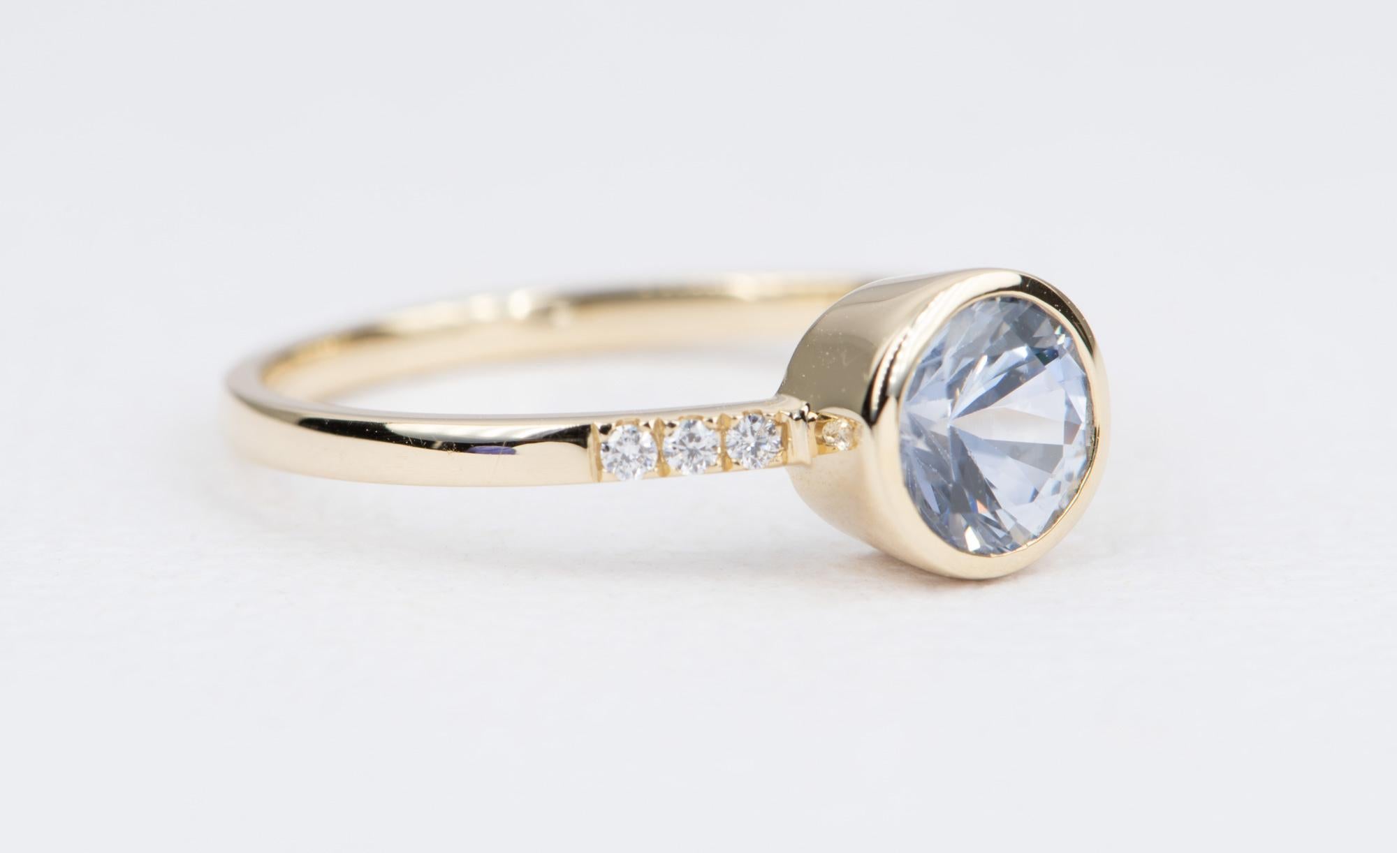 ♥  Classic 14K yellow gold ring featuring a round Montana sapphire bezel set in the center, with a trio of colorless diamonds pave set on each side of the band

♥  Ring size: US Size 6.5 (Free resizing)
♥  Ring width: 1.6mm 
♥  Gemstone: Montana