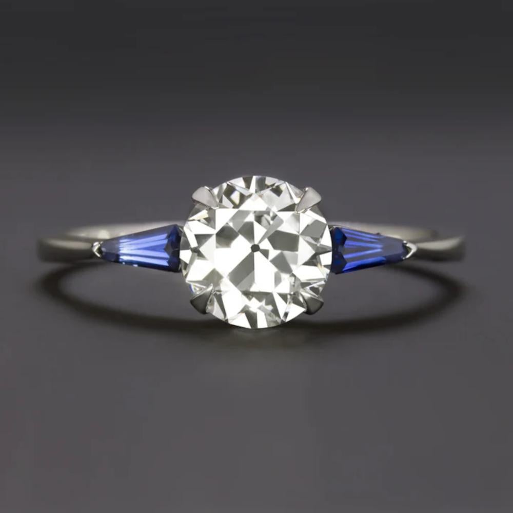Dieser auffällige Ring mit Diamanten und Saphiren ist eine perfekte Mischung aus zeitloser Eleganz und Vintage-Charme. Er besticht durch einen 1,14 Karat schweren Diamanten im alten Übergangsschliff, der ursprünglich aus der Zeit des Art déco