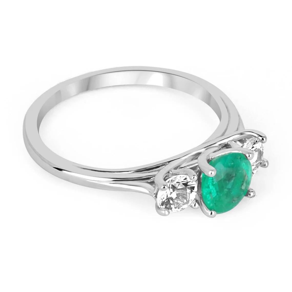 A classic, 14k solid gold natural emerald & diamond three stone engagement ring. A timeless engagement ring featuring a genuine round emerald flanked by two brilliant round diamonds. The Colombian emerald has very good qualities as it is mined from