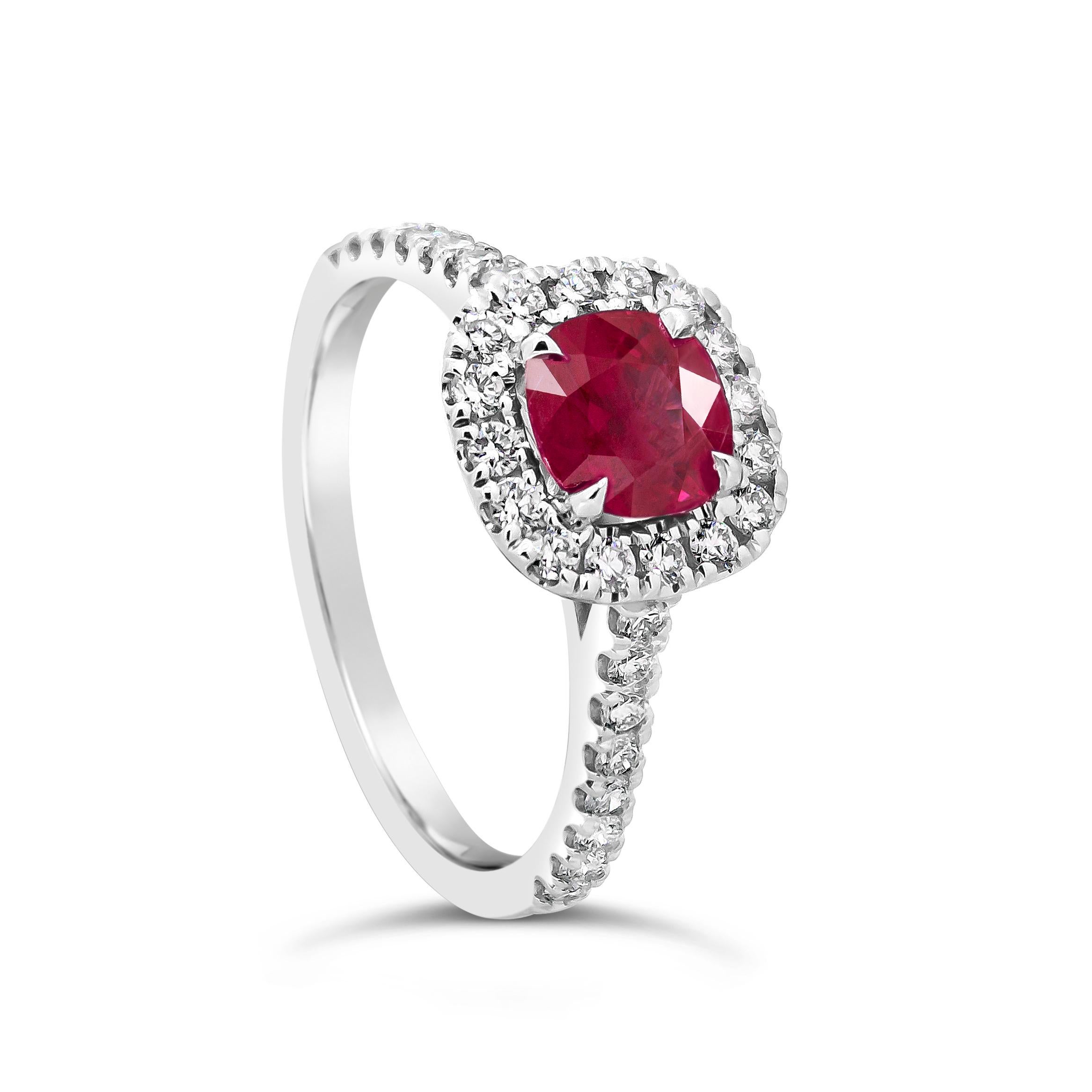 Showcasing a cushion cut ruby weighing 1.15 carats, surrounded by a row of round brilliant diamonds. Set in a diamond encrusted shank made in 18 karat white gold. Diamonds weigh 0.49 carats total. Size 7.25 US.

