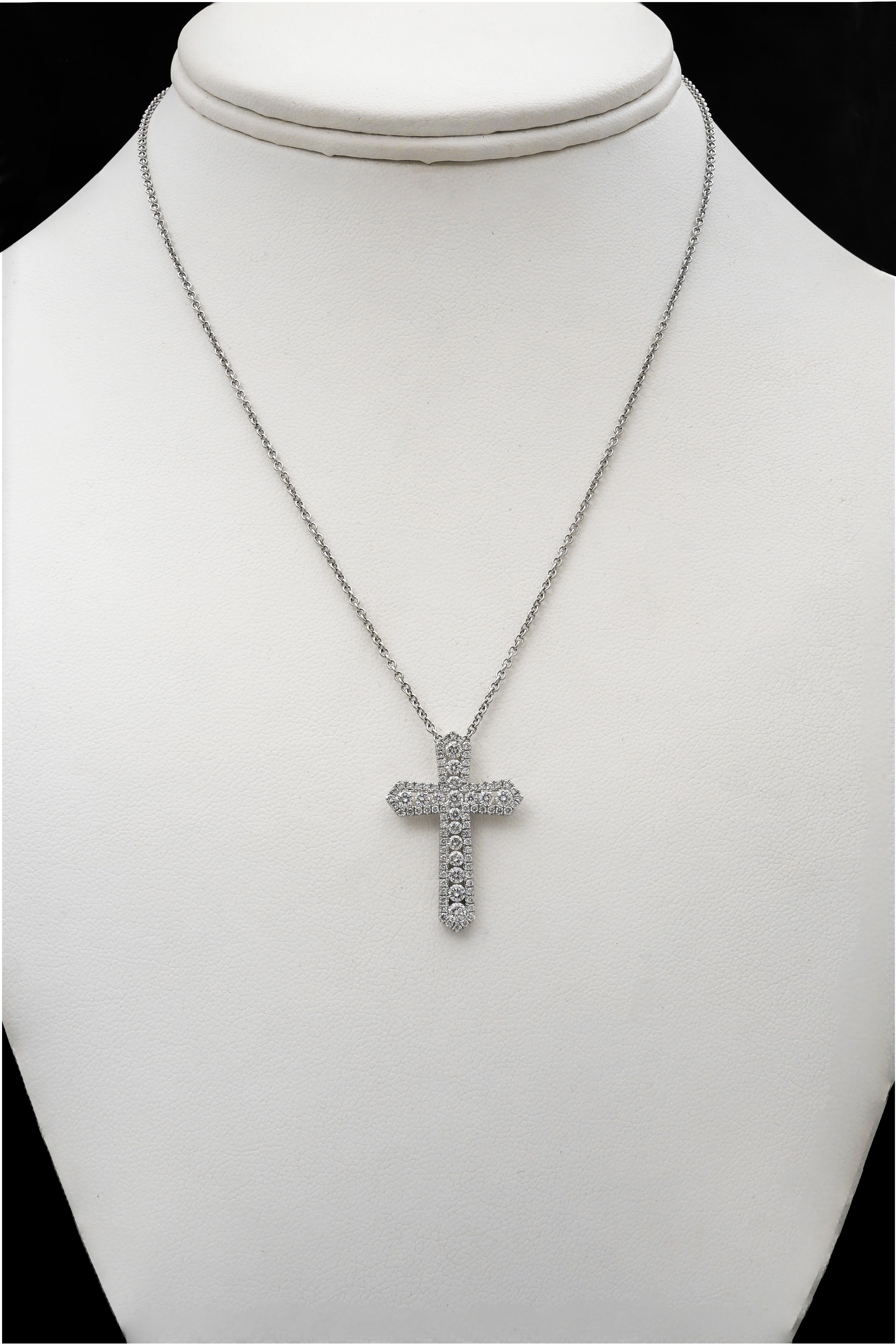 This is an incredibly dazzling cross pendant because of the minimal visibility of the gold composition. Showcases 17 sparkling round diamonds channel set in 18 karat white gold. The channel walls holding the diamonds are encrusted with round melee
