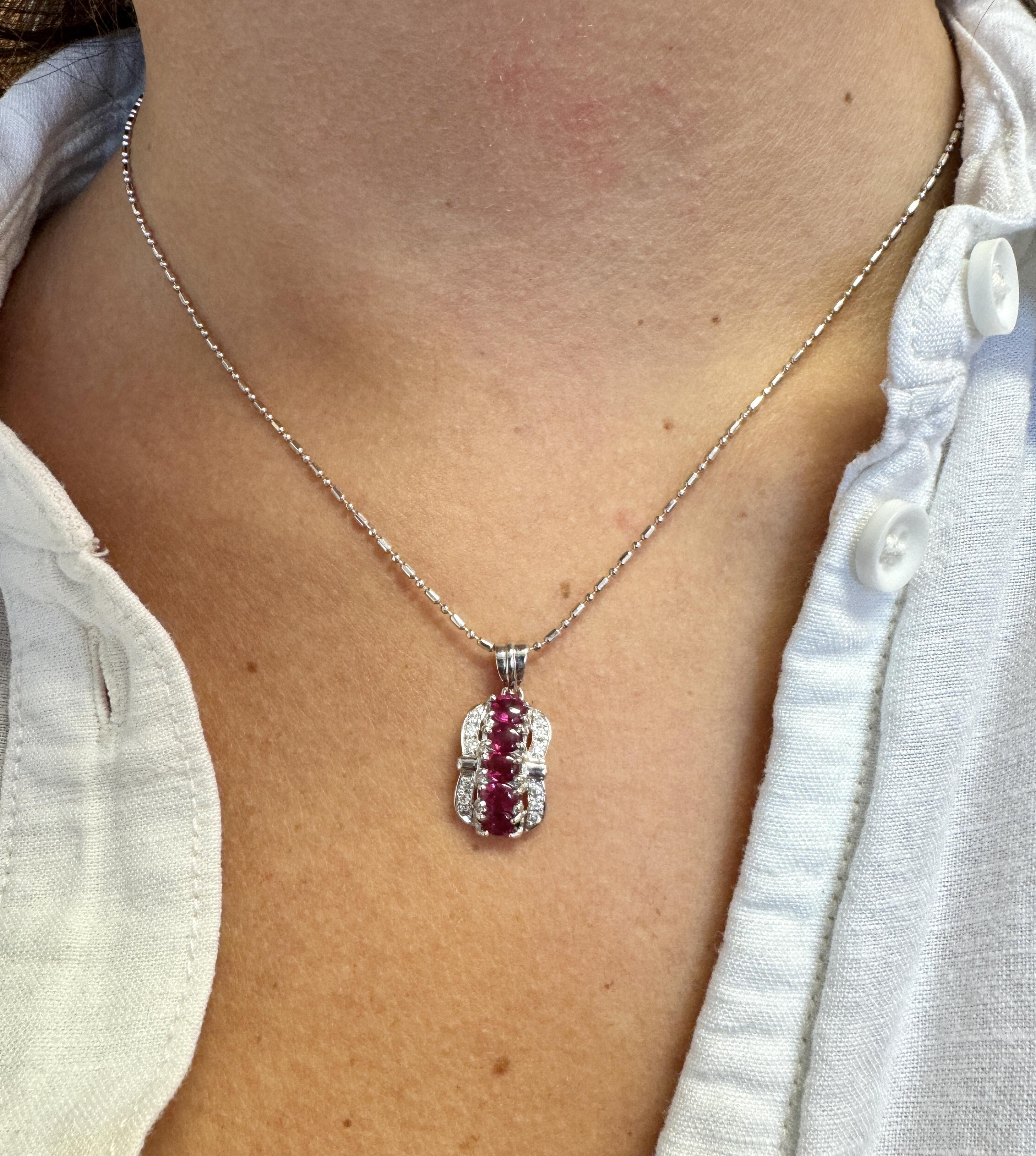 Collana con pendente di rubini e diamanti in platino 850 catene. 

Questo ciondolo presenta 5 rubini dal taglio ovale, per un peso totale di 1,15 carati. I rubini sono allineati verticalmente e fissati in una montatura a griffe. Ai lati dei rubini