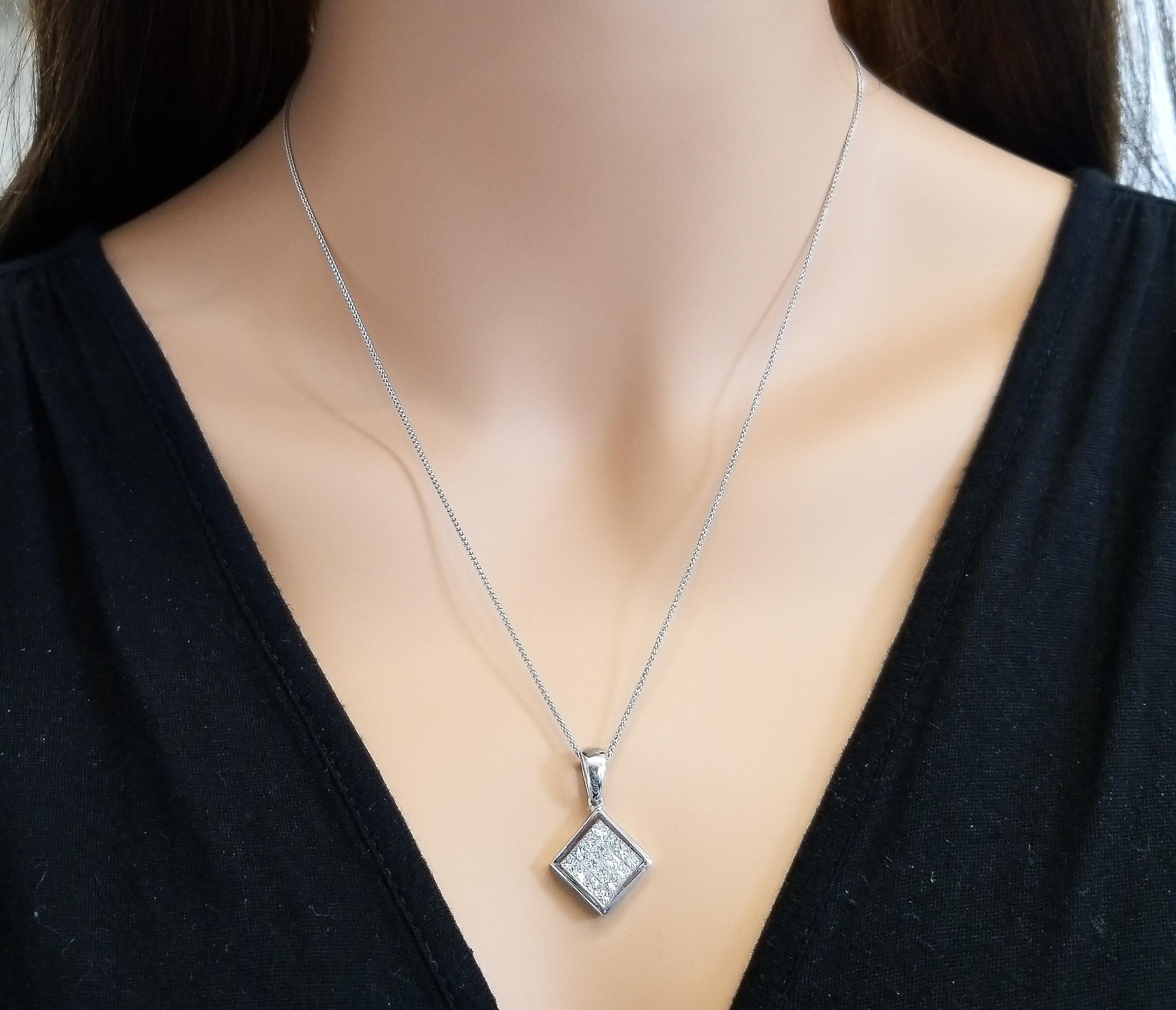 This stylish invisible set diamond pendant is skillfully crafted in 18 Karat white gold. It features a sparkling gathering of invisible set princess cut diamonds, G in color & VS in clarity, that fill up the center. The total diamond weight of this