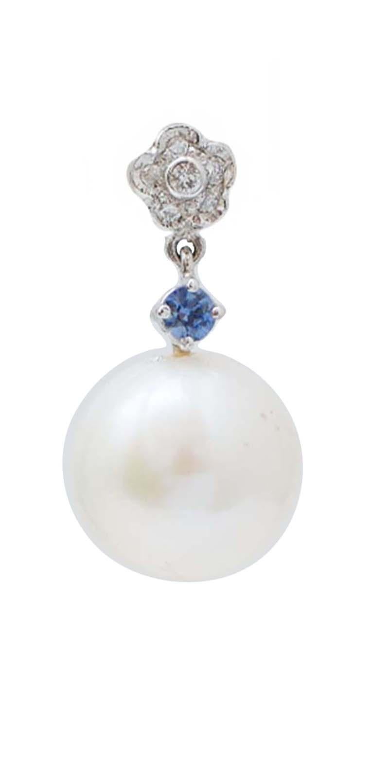 Bellissimi orecchini pendenti con struttura in platino montati con un fiore di diamanti nella parte superiore; al centro, uno zaffiro e, come pendente, una perla bianca.
Questi orecchini sono stati realizzati totalmente a mano da maestri orafi