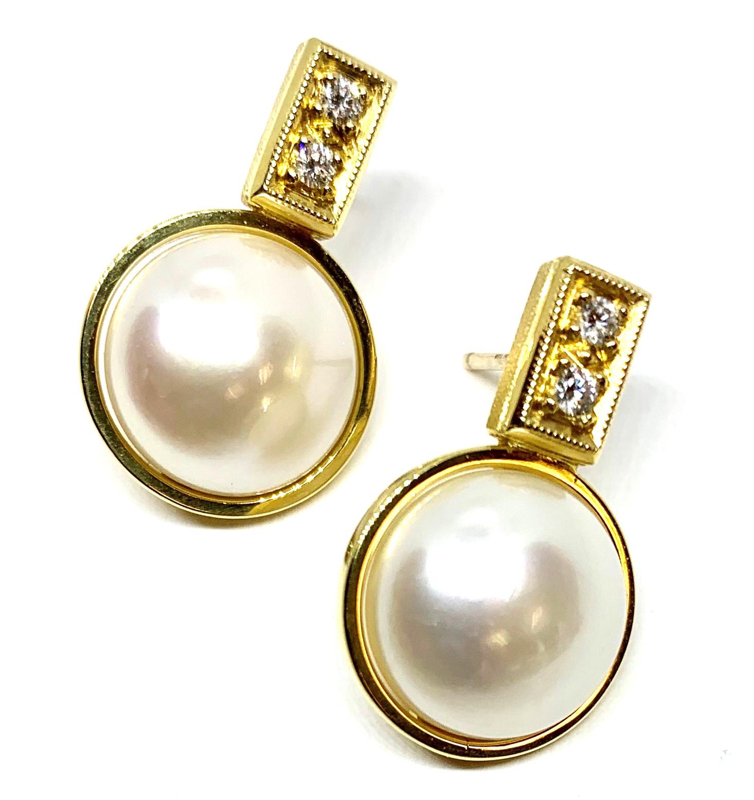 Two giant round button pearls are set in rich, 18k yellow gold bezels and accented with diamonds in these beautiful drop earrings. The pearls are large and lustrous, and pearls go with just about everything! We designed these earrings to nestle the