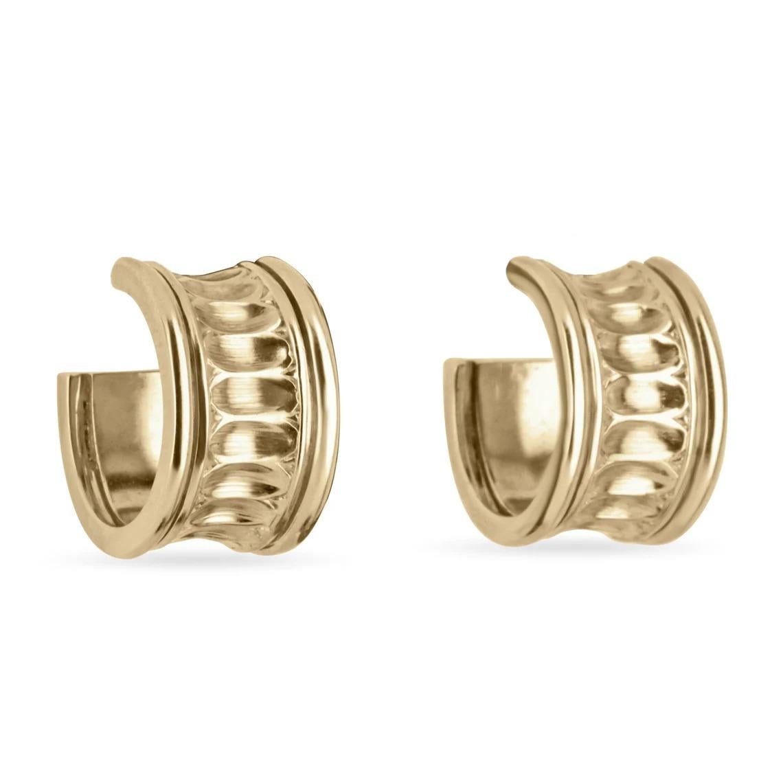 A stunning, simple, yet intricate pair of hoop earrings. Detailed design can be seen within the center ridges. The oval-like shape creates an ongoing illusion for the earrings. Crafted in gleaming 14K yellow gold, the perfect everyday hoops.