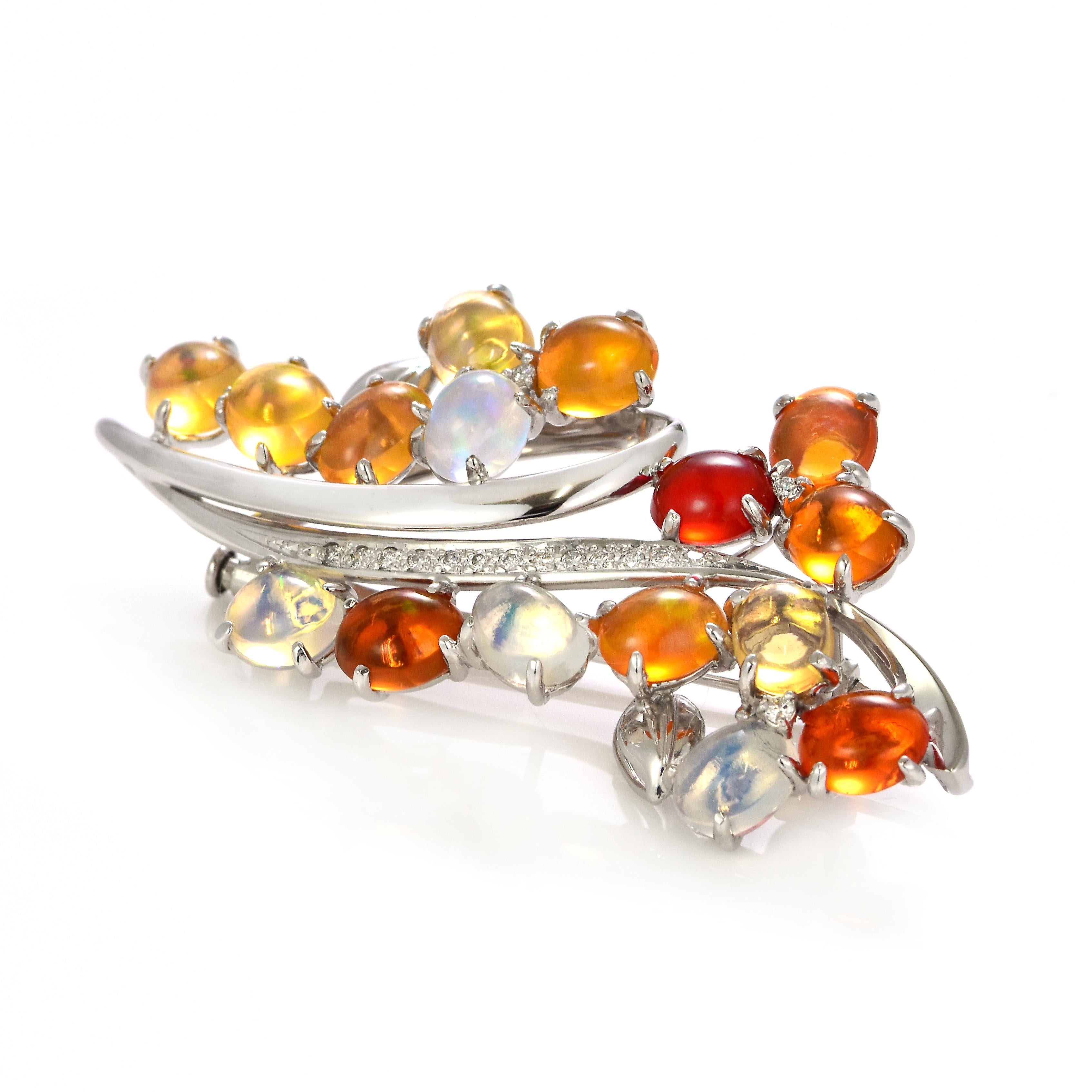 A beautiful brooch featuring 11.54 Carats of Natural Fire Opal and 0.18 Carats of Diamond Accents set in Platinum. Opals are known for exhibiting flashes of rainbow colors known as 