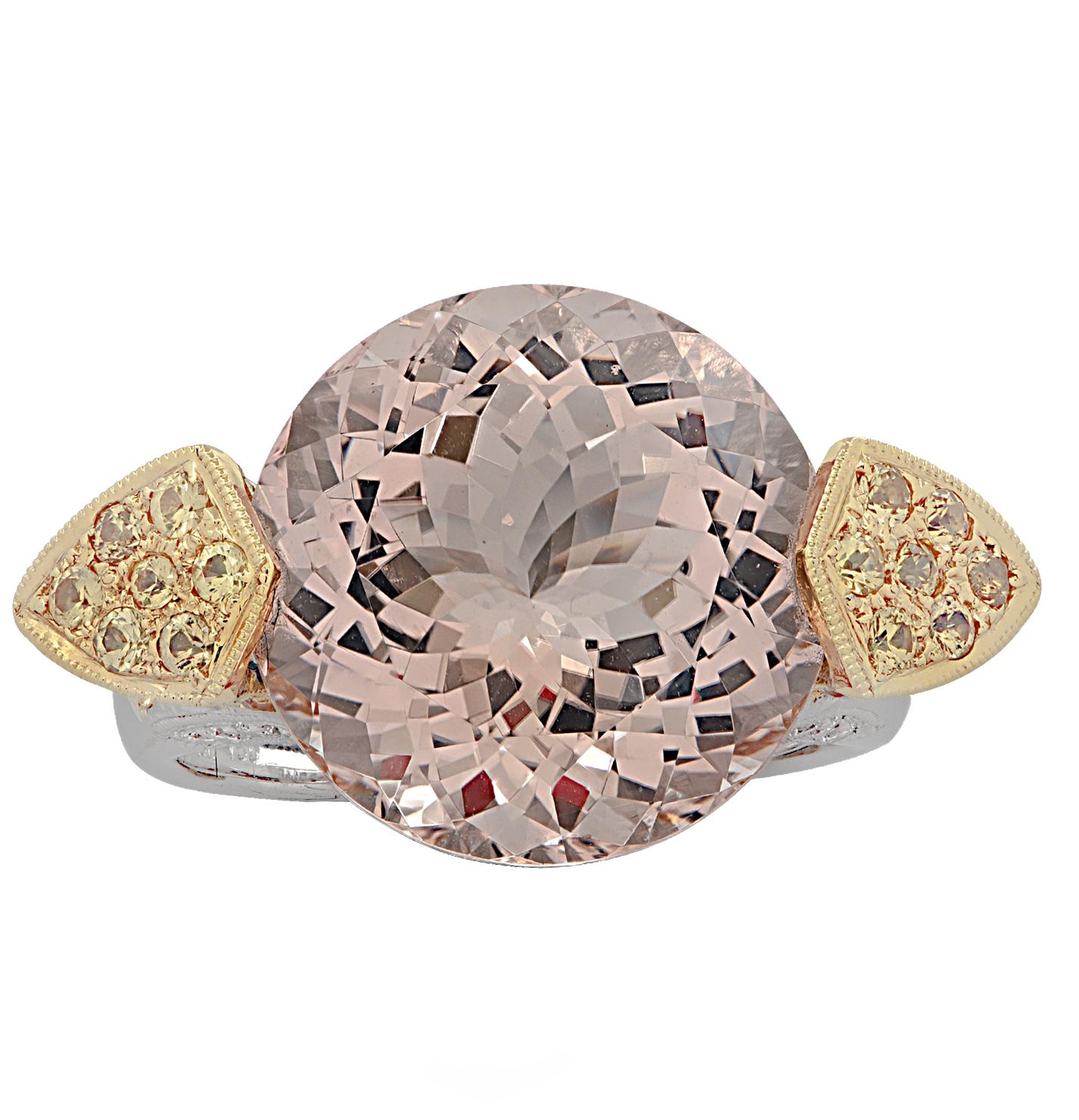 Spectacular cocktail ring crafted in 18 karat yellow and white gold, showcasing a gorgeous round pink morganite weighing approximately 11.55 carats, adorned with 68 round pink and yellow sapphires weighing approximately 1.62 carats total and 42