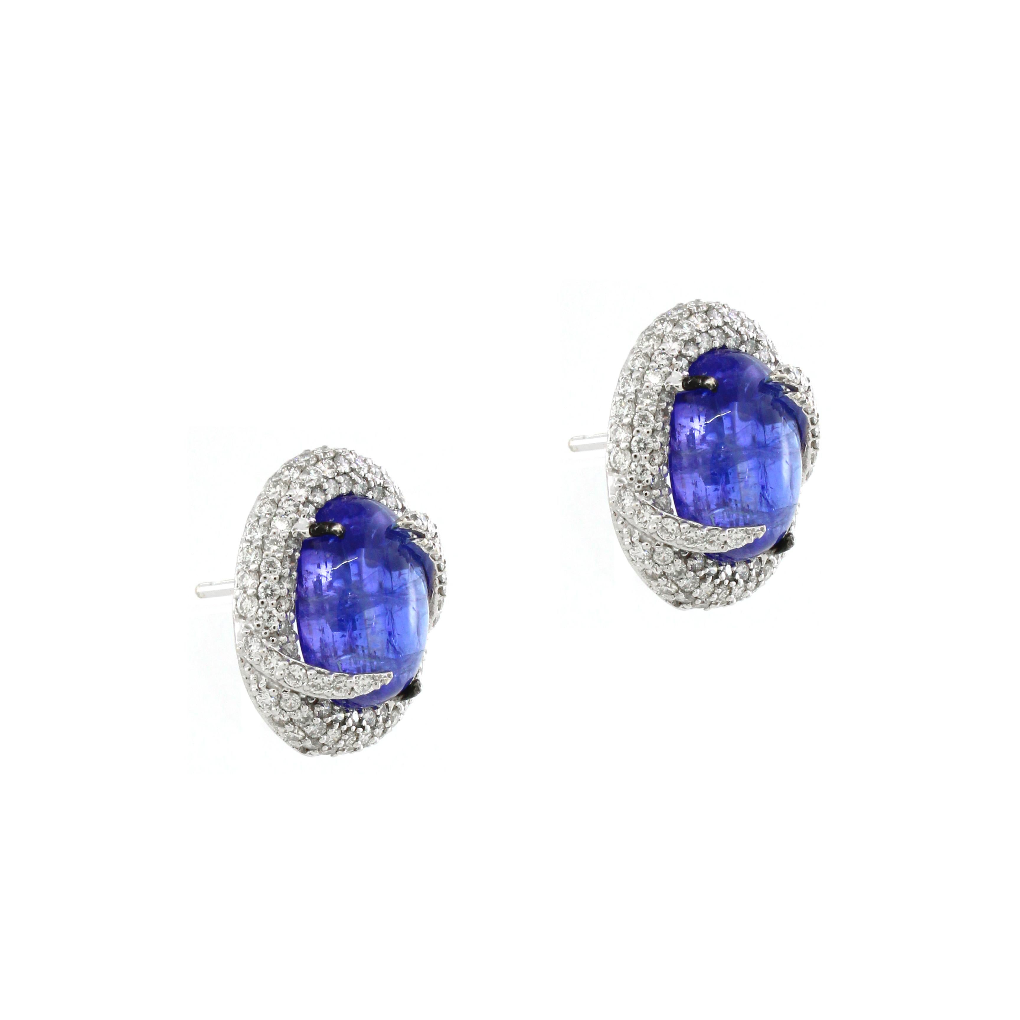 Introducing an exquisite pair of stud earrings that epitomize modern elegance and bold sophistication. Each earring features a breathtaking 11.55-carat oval-shaped tanzanite, celebrated for its mesmerizing blue-violet hue and unparalleled