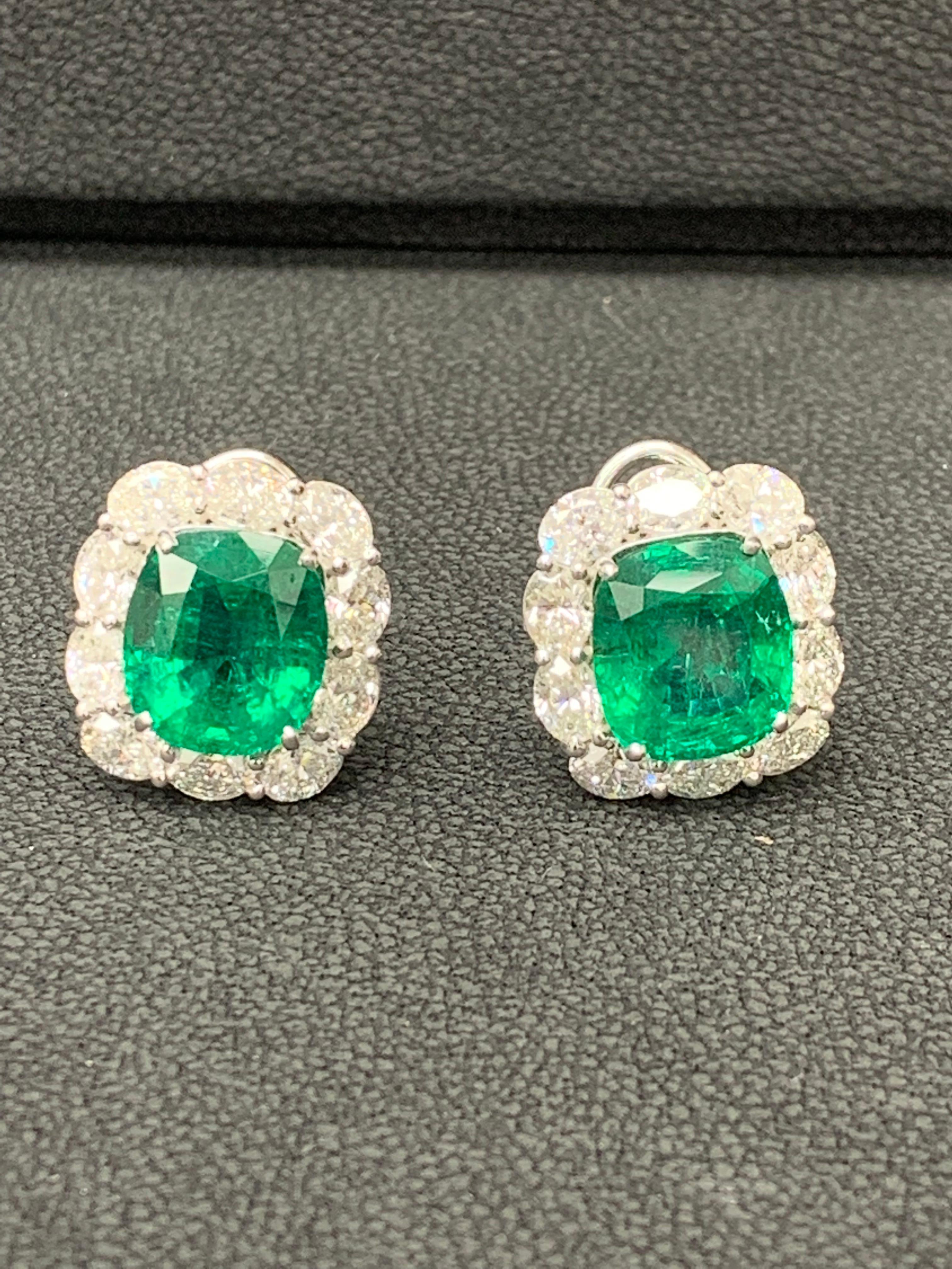 A timeless pair of earrings showcasing two cushion cut emeralds weighing 11.57 carats total, accented with a row of 20 oval shape brilliant diamonds weighing 5.41 carats total. Made in 18k white gold. Omega Clip with post.