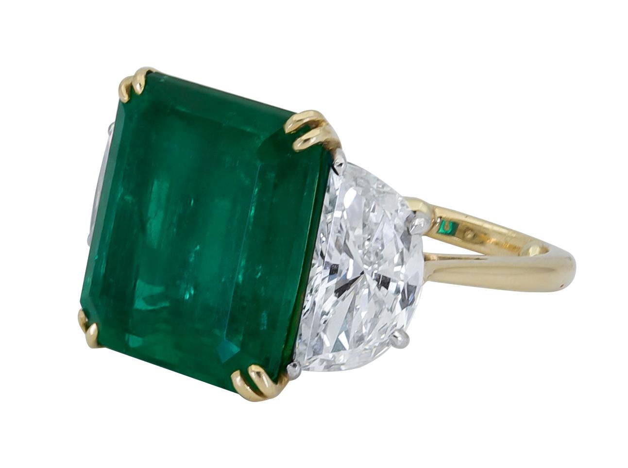 Features a color-rich emerald cut green emerald flanked by two brilliant half-moon diamonds. Set in a delicate and thin 18k yellow gold and platinum mounting.
Green Emerald weighs 11.57 carats and is of Colombian origin.
Size 6 US.
Dimensions: 1.39