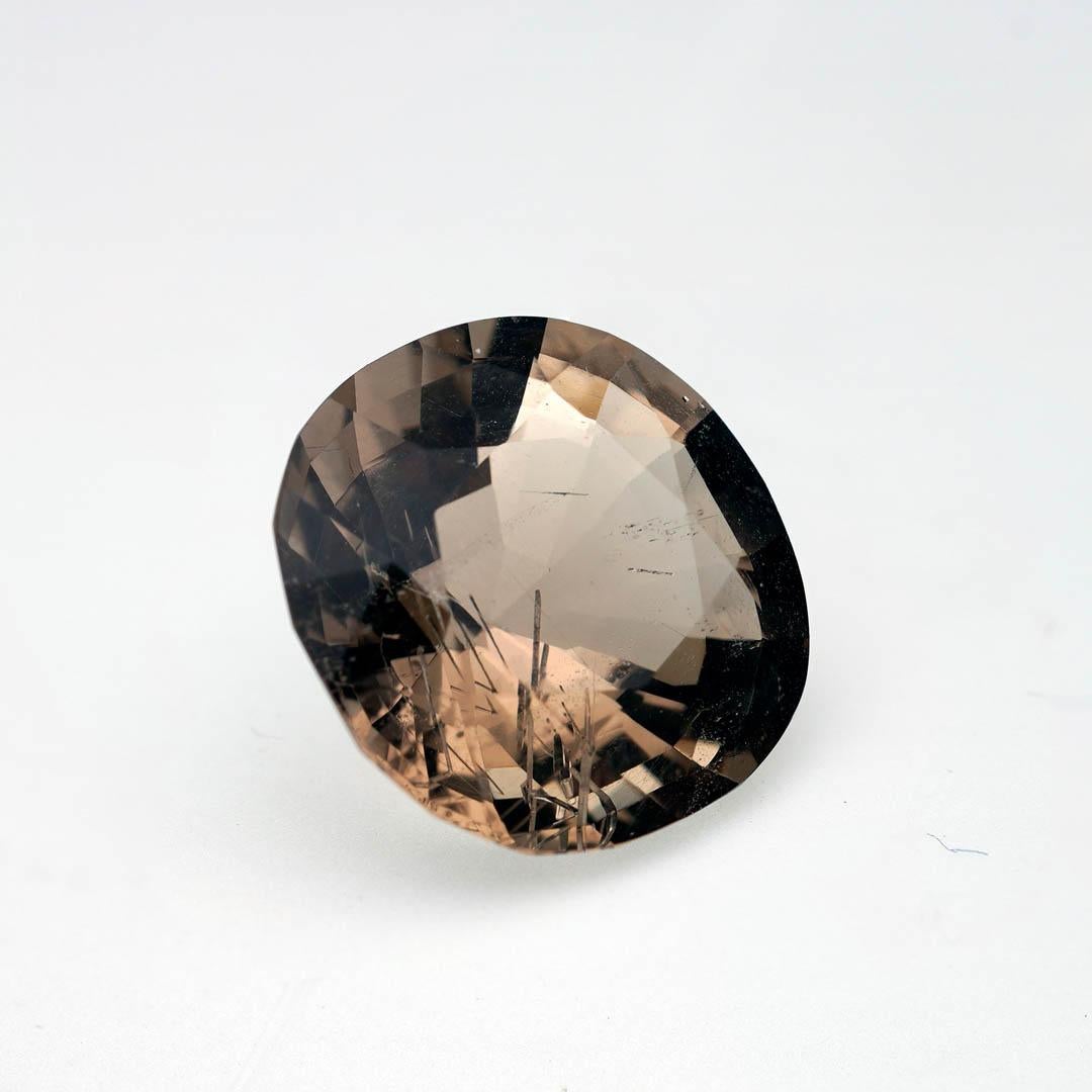 A magnificent 11.59-carat faceted Petalite gemstone from the legendary pegmatites of Minas Gerais, Brazil, this rare collector’s gem radiates a gentle champagne hue with remarkable clarity. Expertly cut to showcase its high transparency and luminous