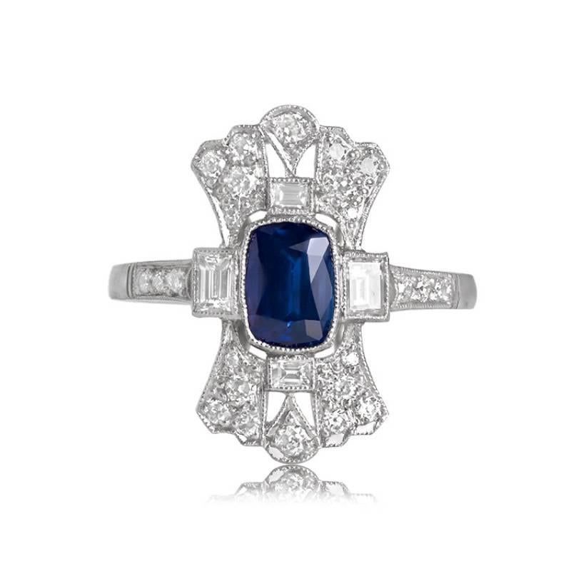 A captivating cushion-cut 1.15-carat sapphire ring, expertly set in handcrafted platinum. The center sapphire boasts an elongated cushion cut, radiating a rich deep blue hue. The ring exudes elegance with its diamond-studded halo encircling the