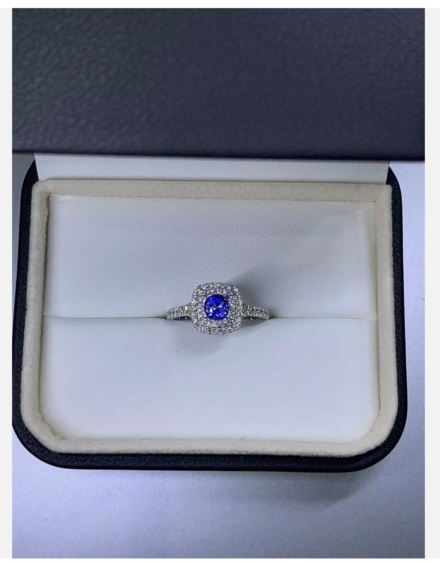 This beautiful Sapphire Diamond Engagement Ring is a true solitaire masterpiece. Crafted with 18ct White Gold, this ring features a stunning 1.15ct round-shaped Sapphire stone as the main piece, surrounded by a halo of smaller diamonds. The ring is