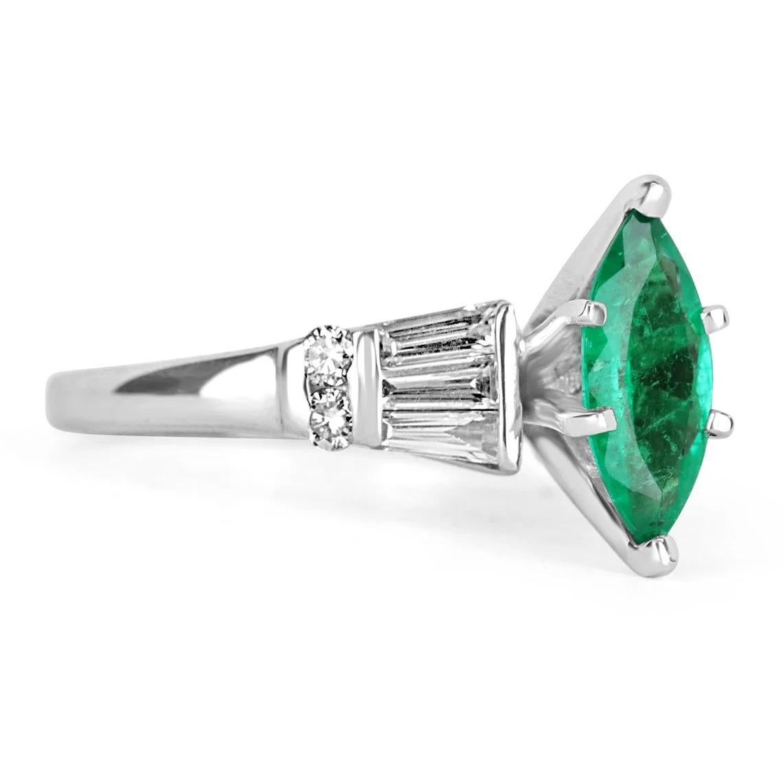 Displayed is a stunning emerald marquise and diamond ring. The center gemstone is an emerald marquise handset in a six-prong setting that allows for a full view of the emerald. Tapered baguette and brilliant round diamonds are tension set on the