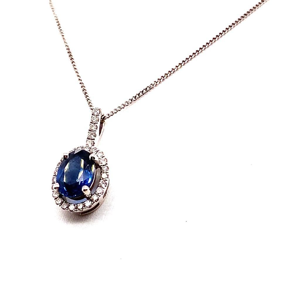 This elegant pendant features an exquisite oval brilliant Blue Sapphire weighing approximately 1.16 Carats at its centre. The royal blue hues of this luscious sapphire are surrounded by a halo of glimmering diamonds weighing approximately 0.14