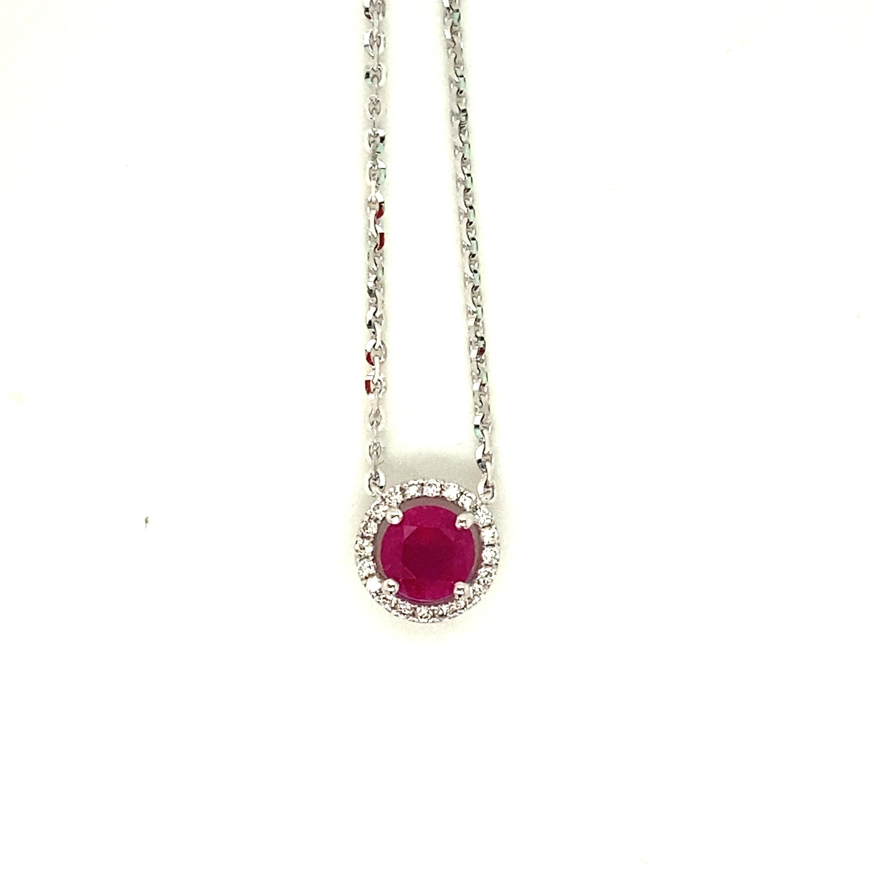 Precioso colgante con un rubí rojo intenso natural de talla ovalada de 1,16 quilates en el centro, rodeado de un halo de diamantes blancos de talla redonda brillante de 0,13 quilates. El rubí es natural, posee una intensa saturación de color rojo