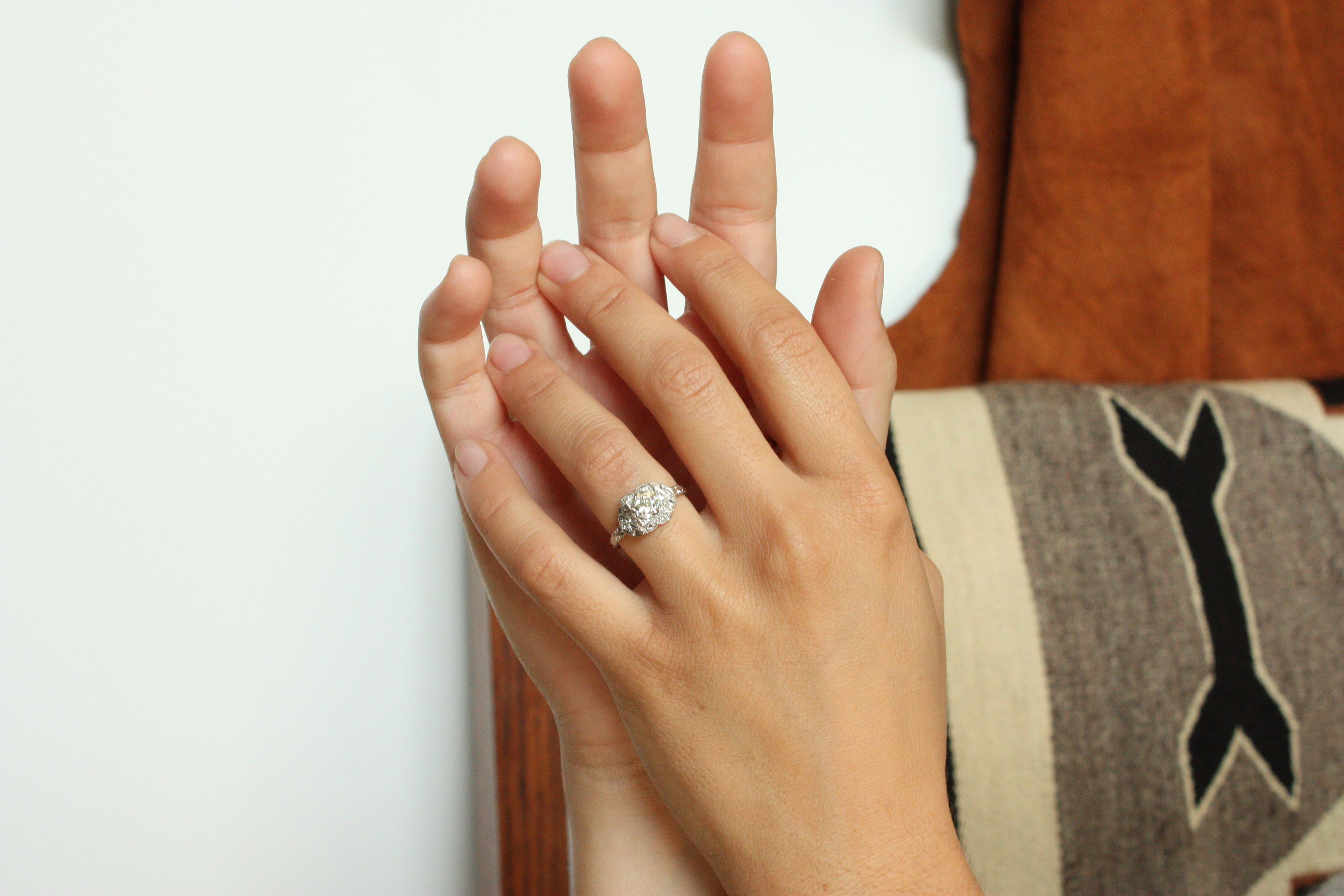 Vintage Art Deco diamond engagement ring. Platinum semi-mount setting circa 1935 with a 1 carat Old European cut round brilliant center diamond (clarity SI-2, color L) and 8 single-cut and full-cut side diamonds totaling approximately 0.16 carats