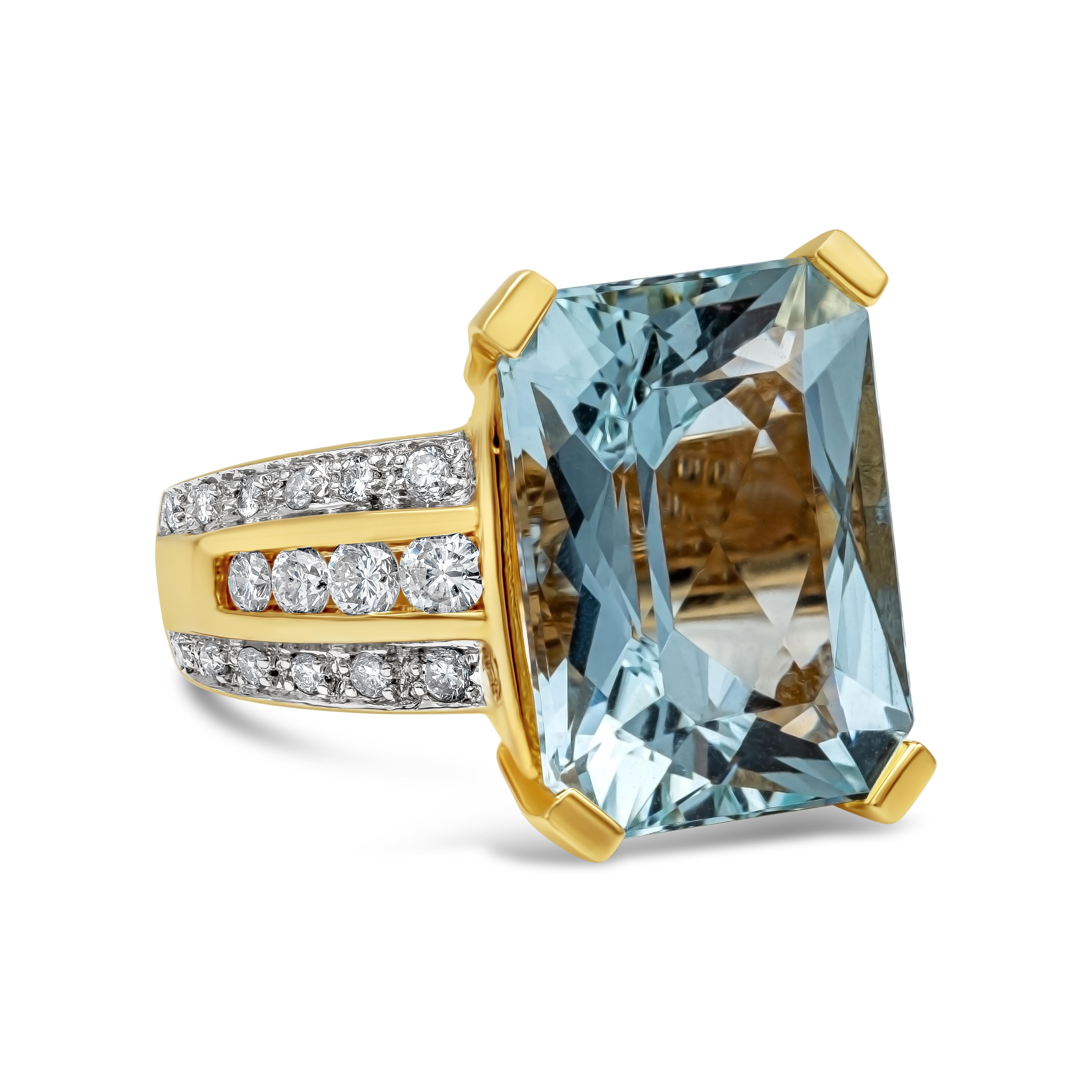 A gorgeous ring showcasing a vibrant 11.60 carat emerald cut aquamarine, set in a three-row diamond mounting made in 18k yellow gold. Diamonds weigh 0.40 carats total and are approximately G-H color, SI clarity. 