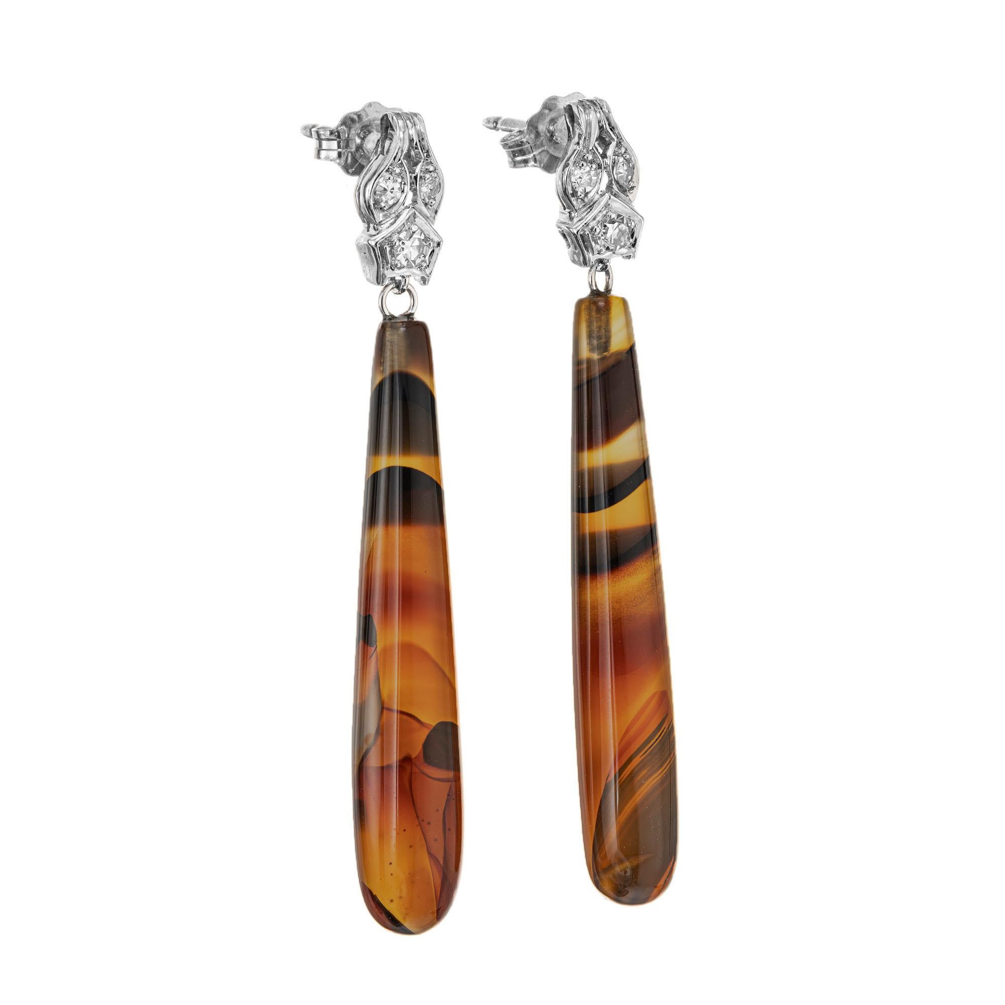 Vintage 1940's banded agate simple dangle earrings with 6 bead set diamonds in platinum tops. 

2 pear shaped black brown cabochon banded agate cylinders, approx. 11.62cts
6 single cut diamonds, G VS approx. .8cts
Platinum 
Stamped: PT950
4.6