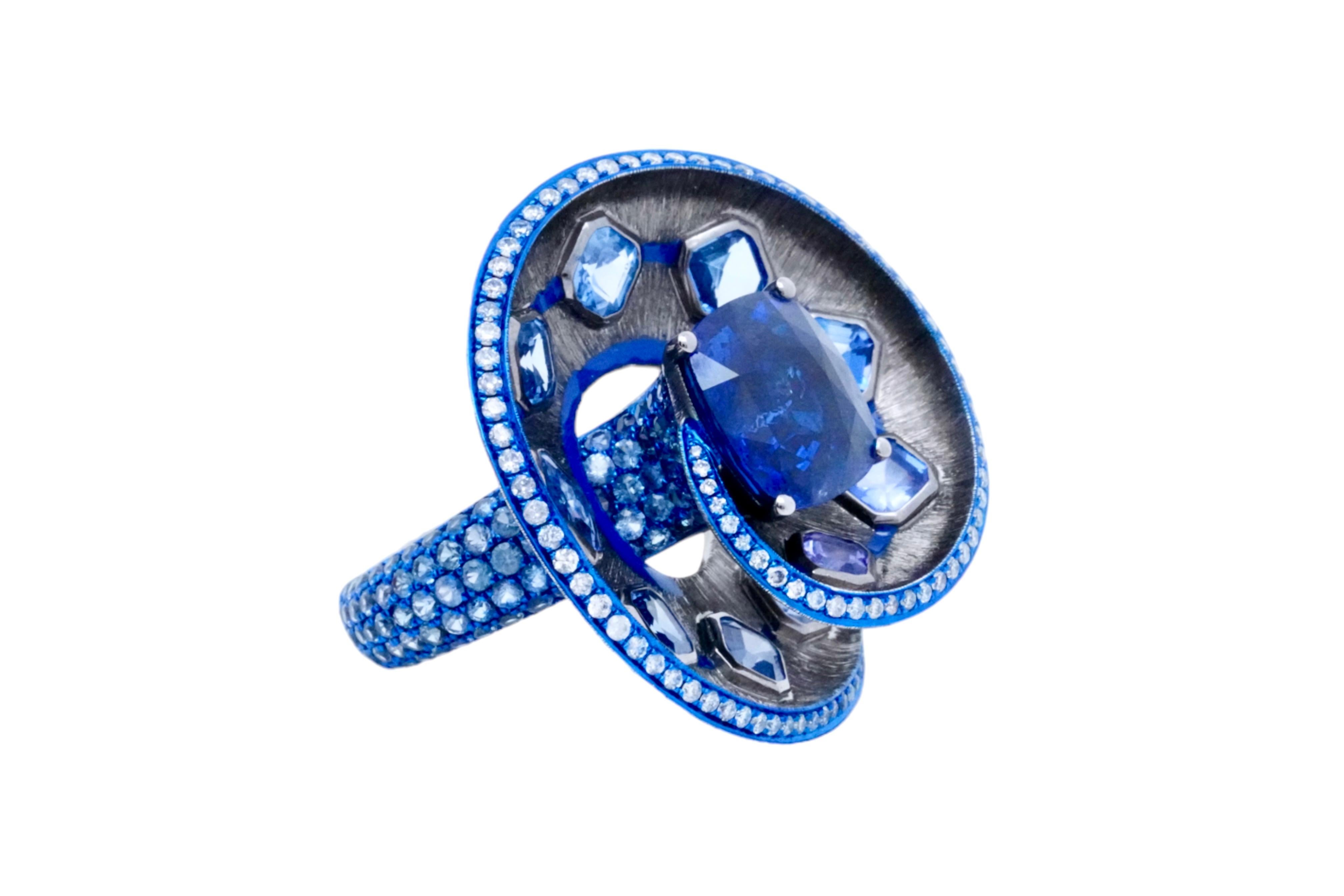Wir stellen den exquisiten Deep Blue Waterspout Ring vor, ein fesselndes Stück aus Austy Lees prestigeträchtiger 'The Garden of Myth Collection'. Dieser faszinierende Ring zeigt ein anmutiges Spiraldesign, das mit einem prächtigen 6,08-Karat Sri