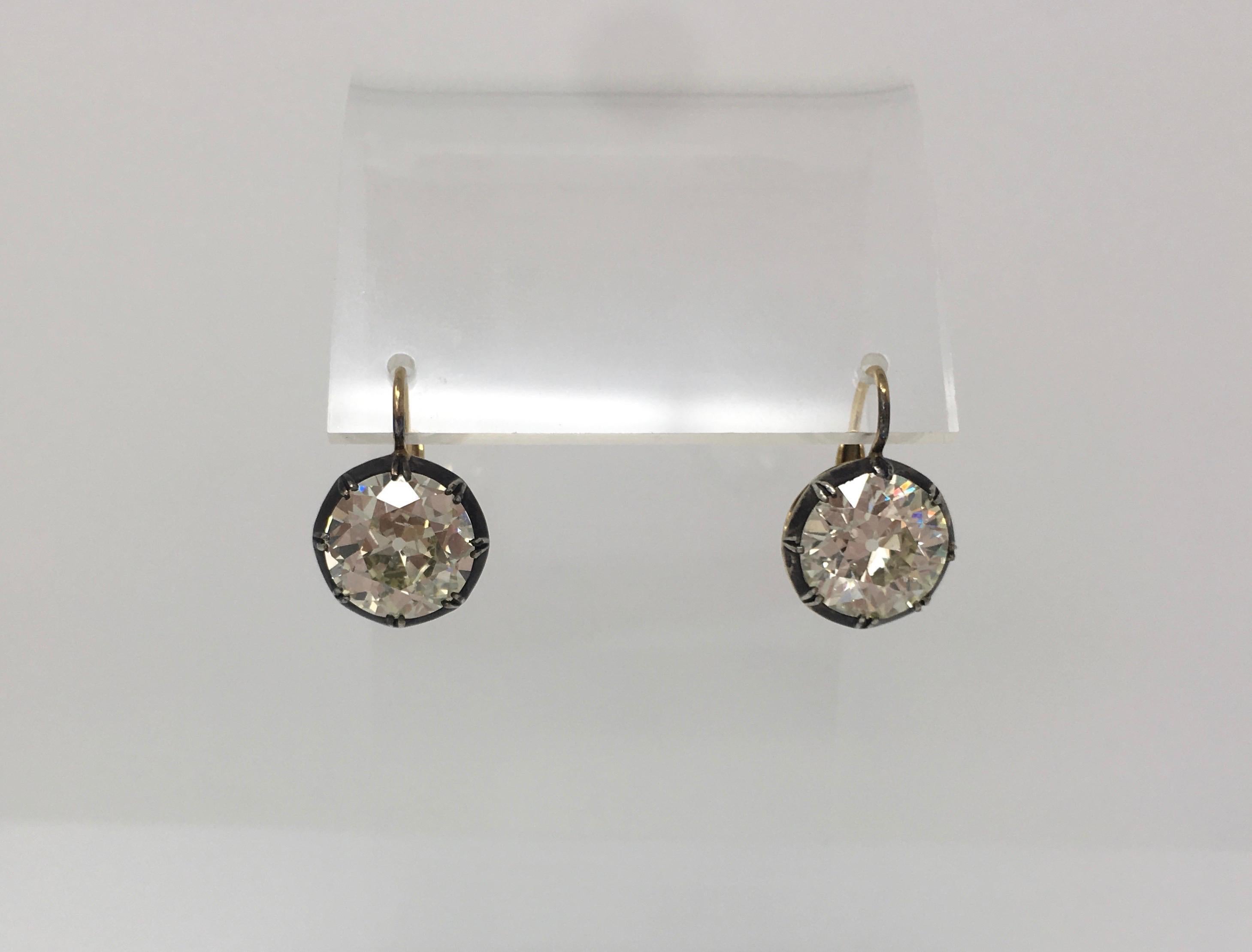 A pair of lovely antique old European cut diamond antique style dangle earrings features two large old European cut diamonds weighing 5.66 carat and 6.01 carat a total of 11.67 carat. The diamonds have L-M color and S I clarity ( eye clean). These