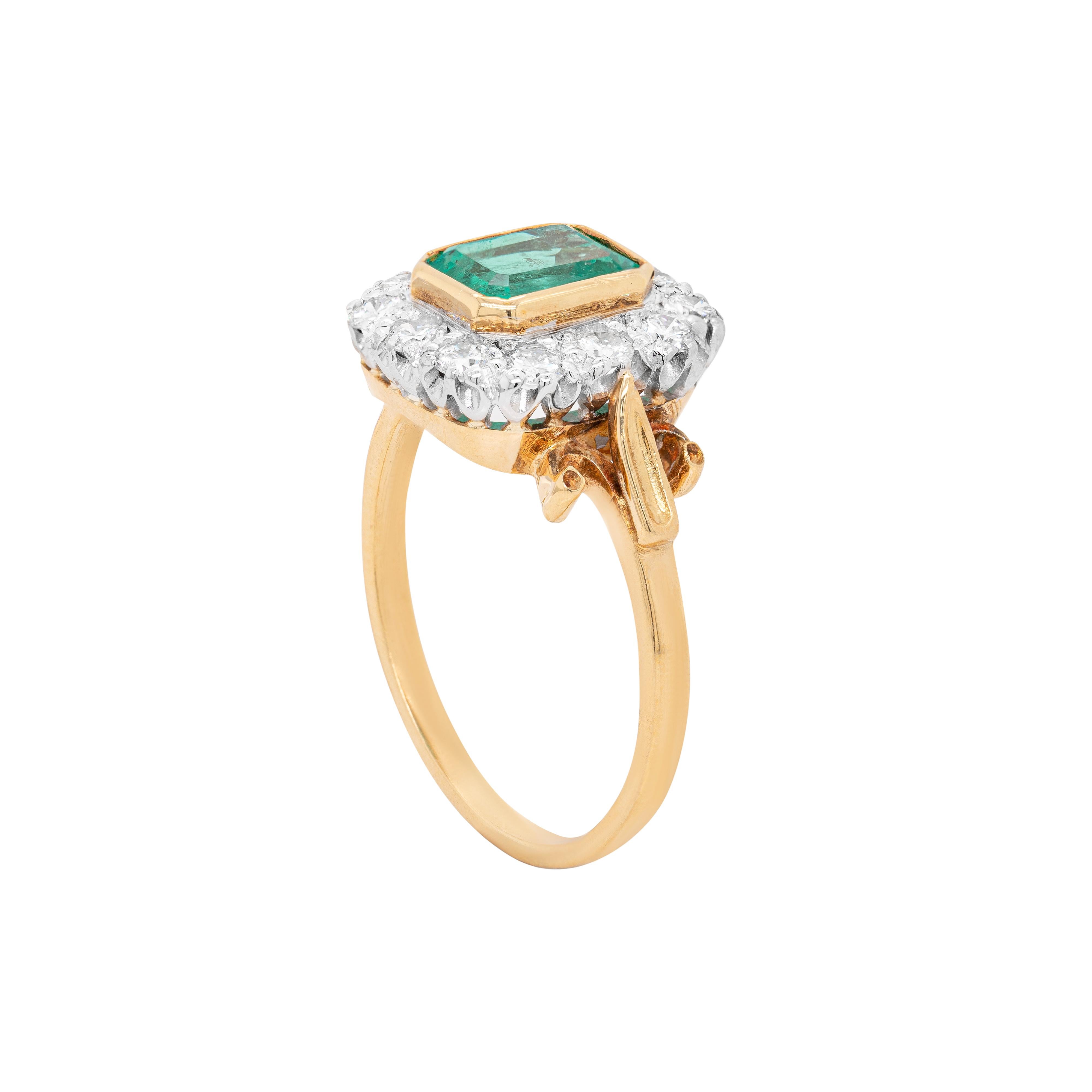 This gorgeous ring features a 1.16 carat emerald in the centre, rubover set in 18 carat yellow gold. The green gemstone is beautifully surrounded by 12 fine quality round brilliant cut diamonds totalling 0.52ct, all mounted in contrasting 18 carat
