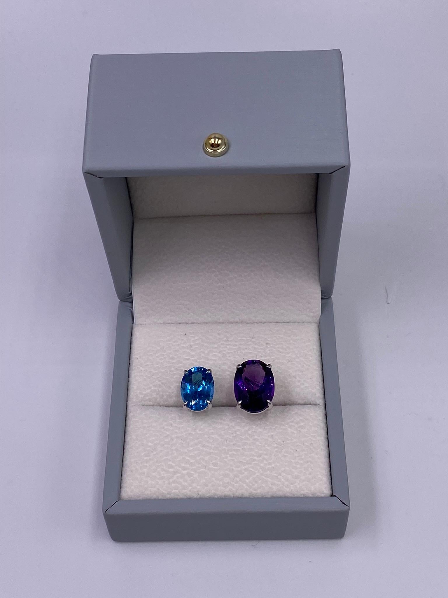 This stunning 18 K white gold ring features two gorgeous oval shaped gems: amethyst and blue topaz. This special ALPENGEM design beautifully demonstrates the gemstones on the unclosing ring construction, which makes it lighter and adds some space to