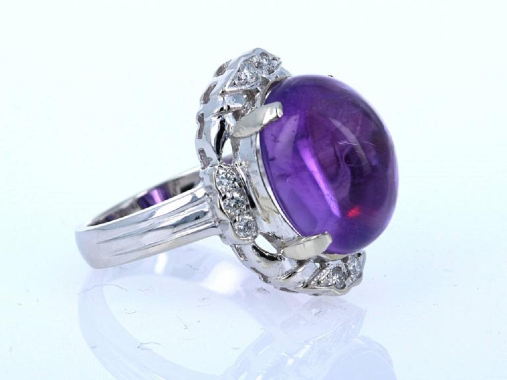 This gorgeous cocktail ring has a huge Oval Cut Cabachon Amethyst set in the center of the ring that weighs 11.45 carats. It is surrounded by 10 Round Cut Diamonds that weigh 0.25 carats.  The total carat weight of the ring is 11.70 carats.  

The