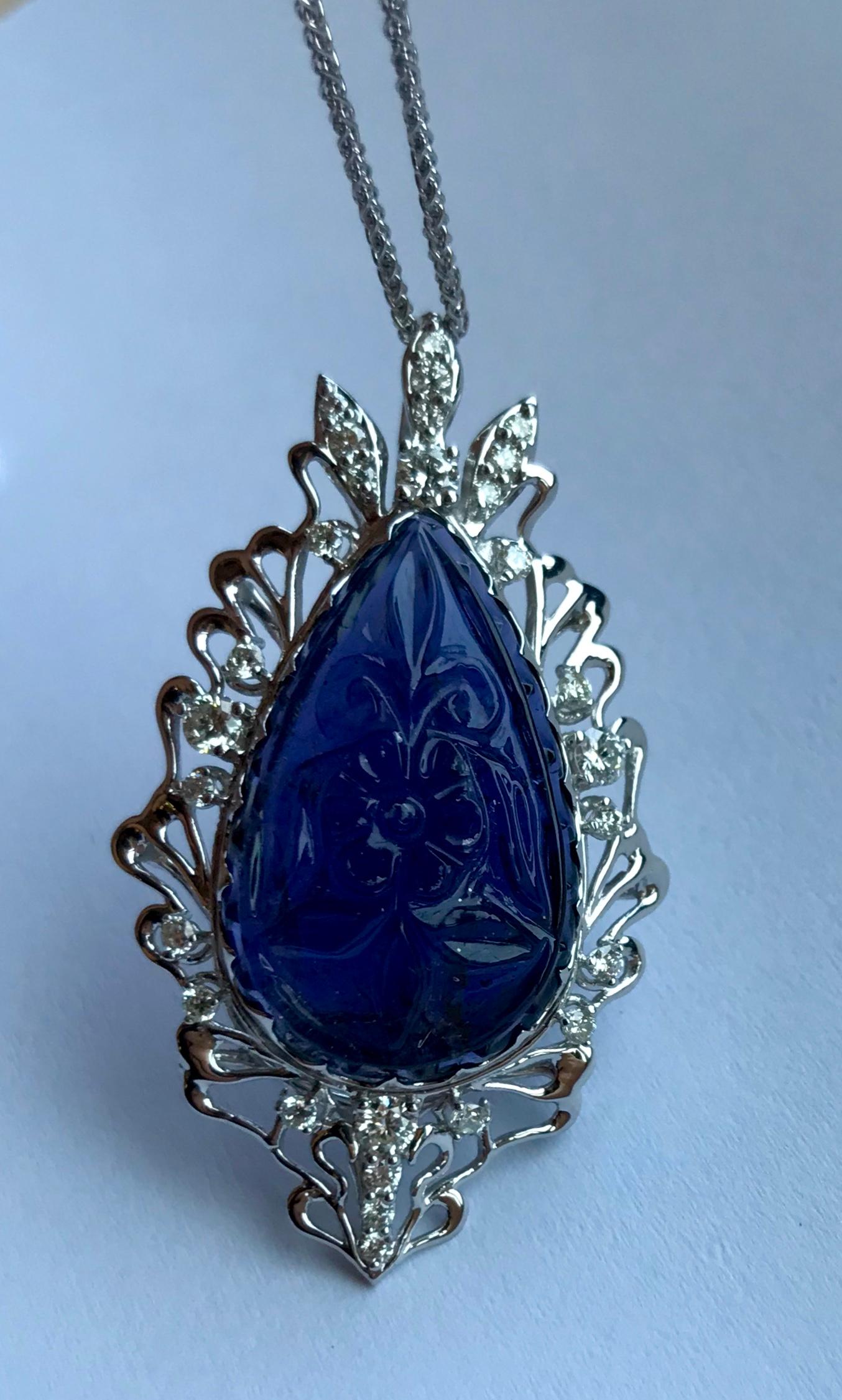 Material: 14k White Gold 
Center Stone Details: 11.70 Carat Pear Shaped Iolite - 25 x 15 mm
Diamonds:  28 Round Diamonds at 0.60 Carats.  SI Quality /  H-I Color
Chain:  18 inch

Pair this with our 11.84 Carat Carved Iolite Earrings and Pear Shaped